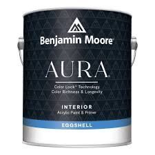 A gallon can of Benjamin Moore Aura interior eggshell paint and primer, dark blue with white text.