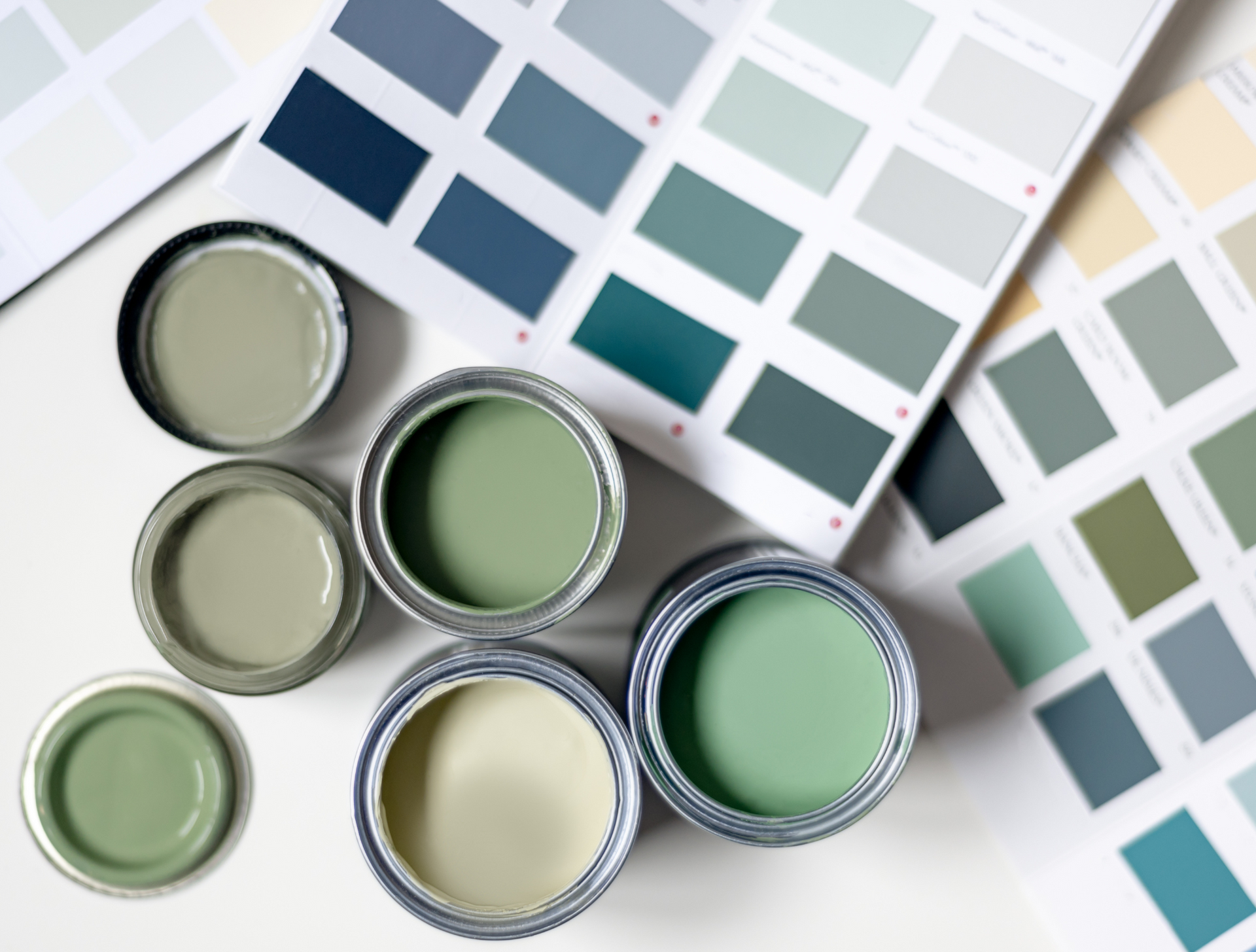 Several cans of paint are sitting next to a color palette