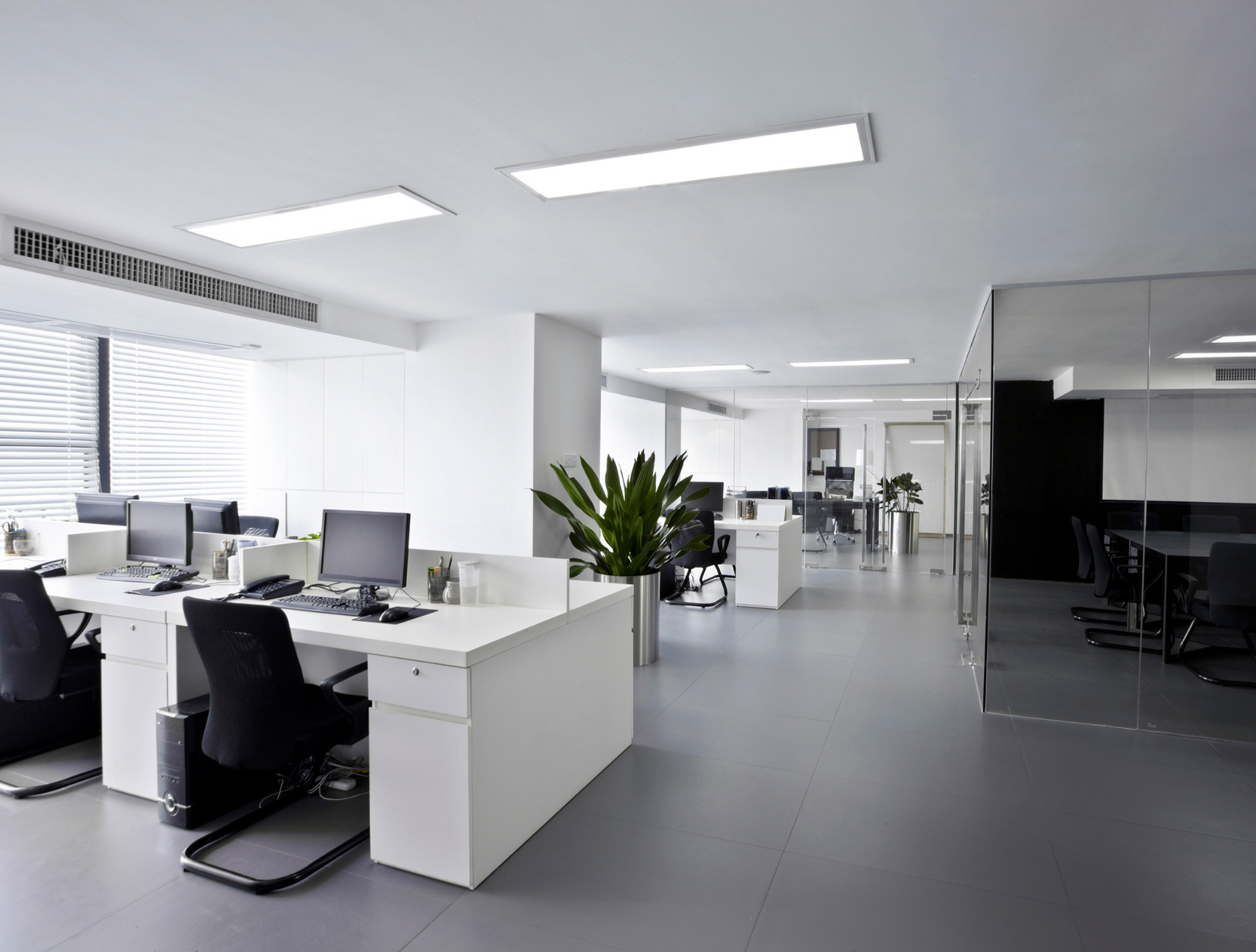 A large empty office with a lot of desks and chairs.