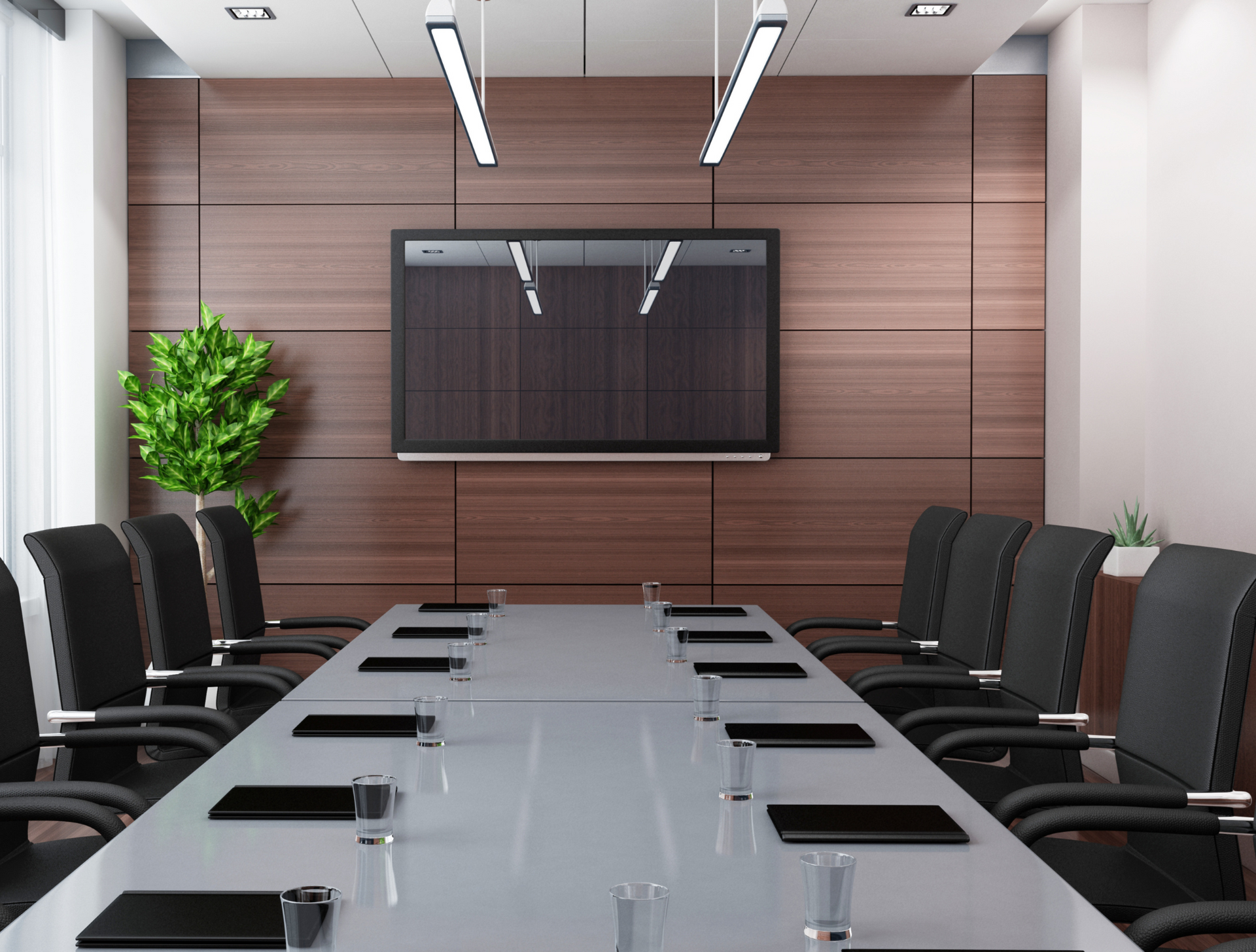 A conference room with a long table and chairs and a flat screen tv