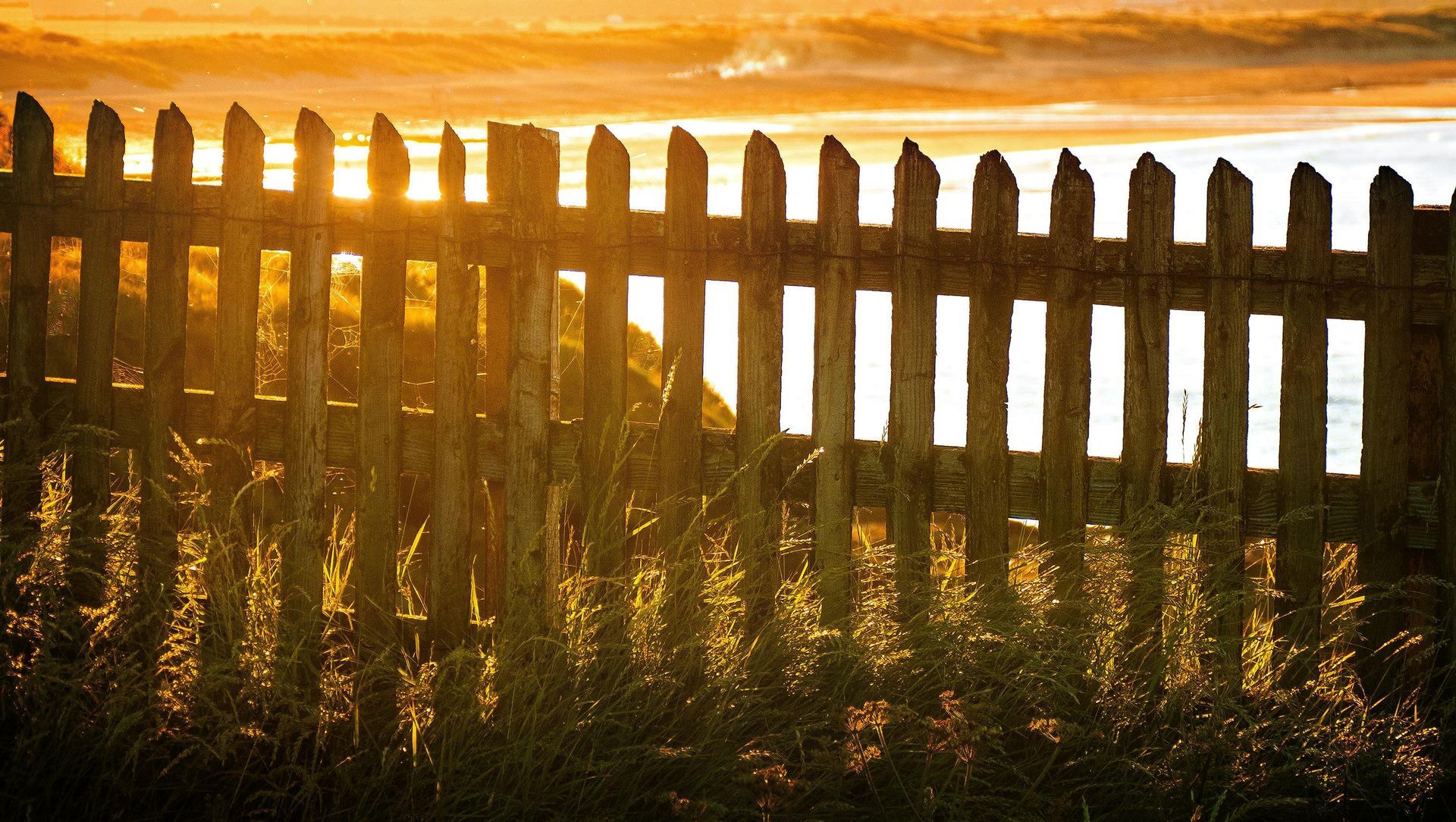 A wooden fence with a sunset in the background