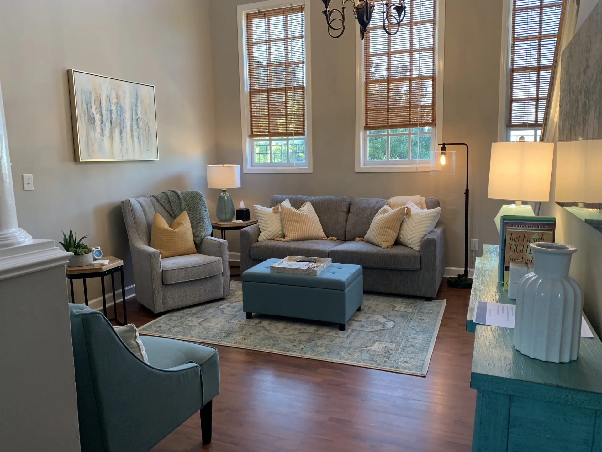 A living room with a couch , chairs , and ottoman.