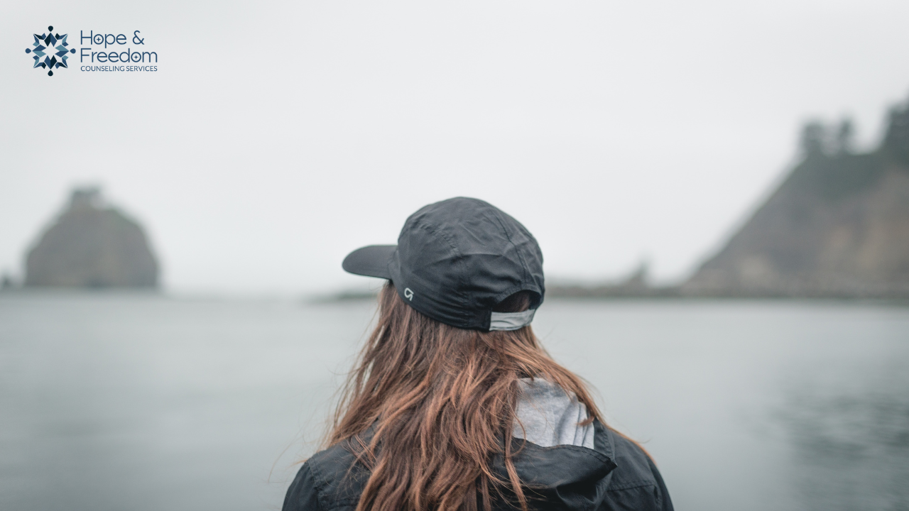 Woman by the water wondering why she's still struggling years after betrayal trauma and infidelity