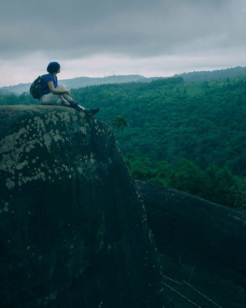 woman on cliff looking at trees thinking she needs a therapeutic consultation