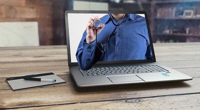 A laptop computer with a man holding a stethoscopee on the screen.