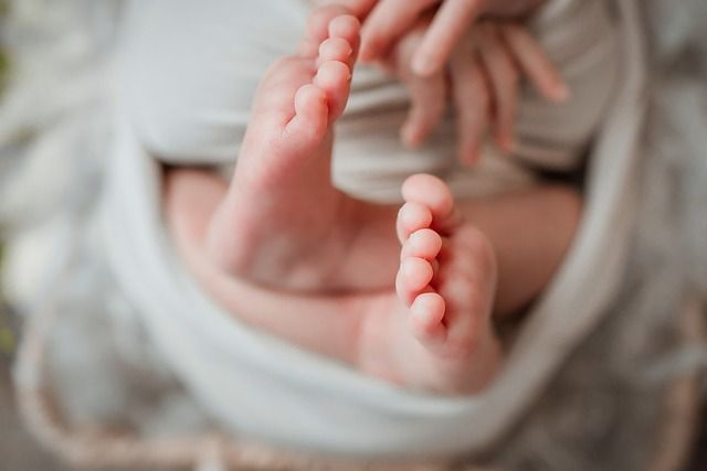 A close up of a baby 's feet wrapped in a blanket.
