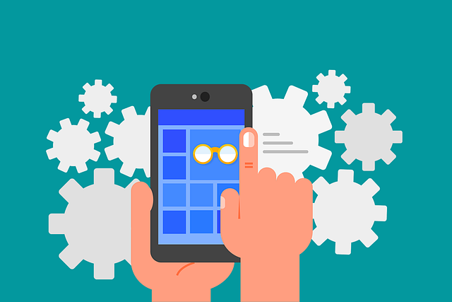 A hand is holding a cell phone with gears in the background.