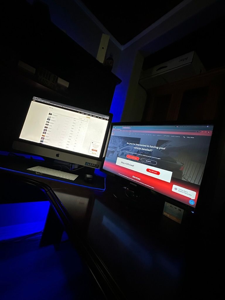 Rollers Media: Two computer monitors on a desk in a dark room with blue lighting, displaying web pages.