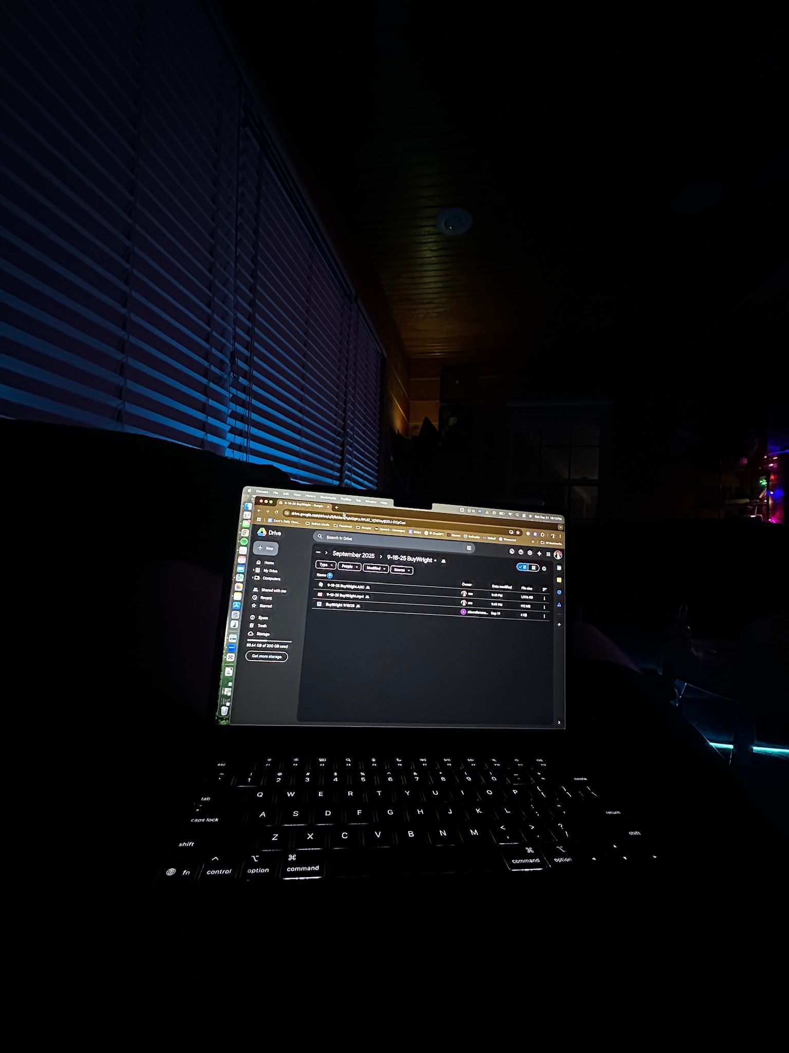 Rollers Media: Laptop in dark setting, keyboard illuminated, screen displaying a file directory, blue light from window.