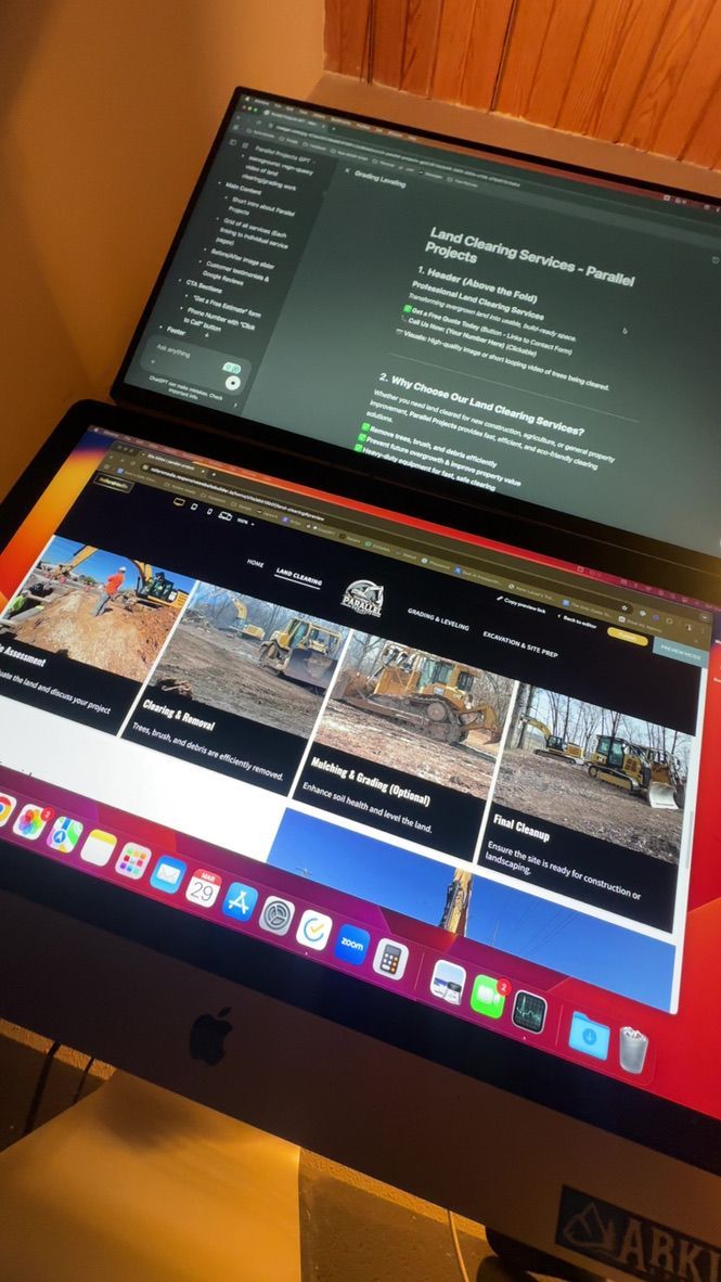 Two computer monitors showing website and code side-by-side, indoors.