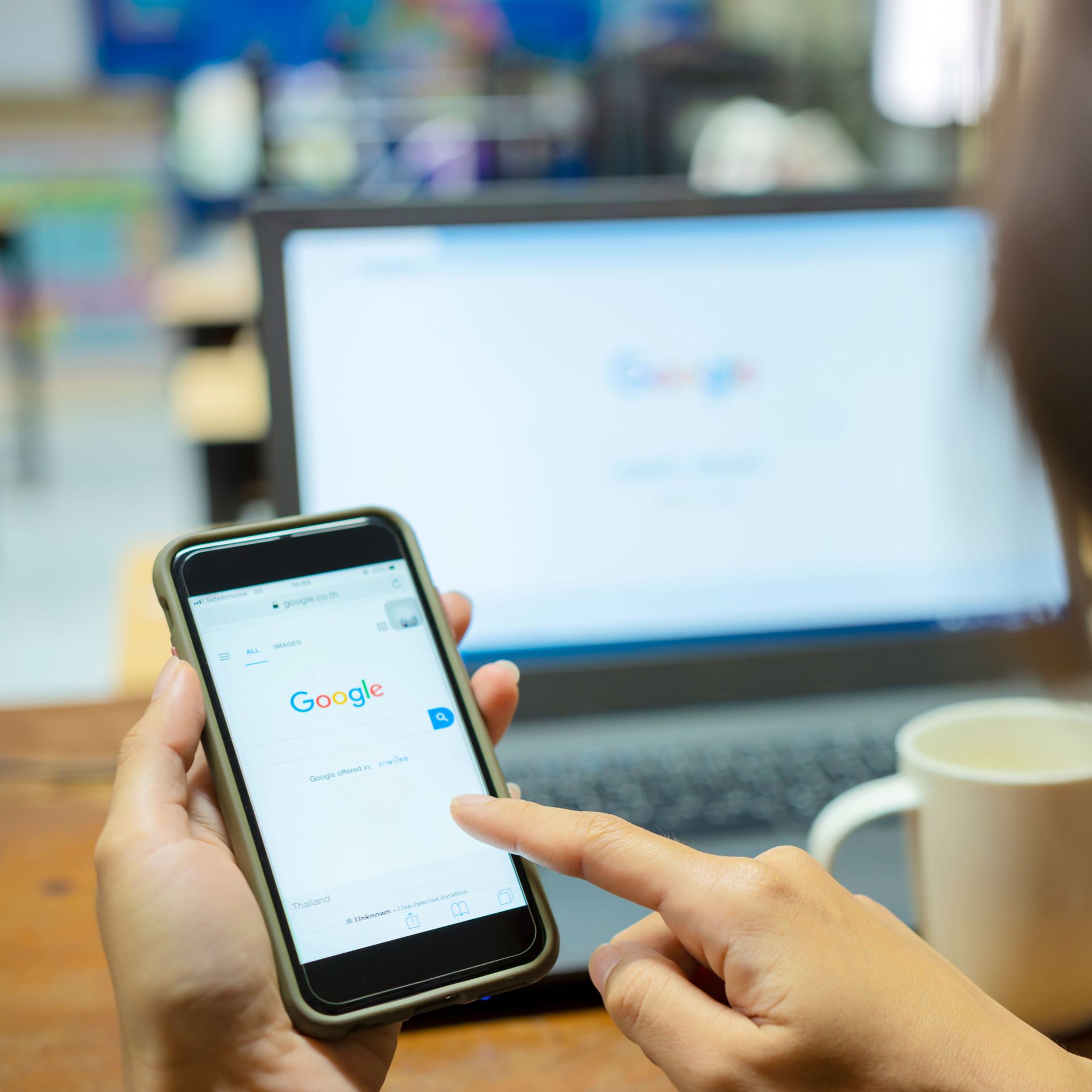 Rollers Media: Person using phone with Google search open, laptop also showing Google search.