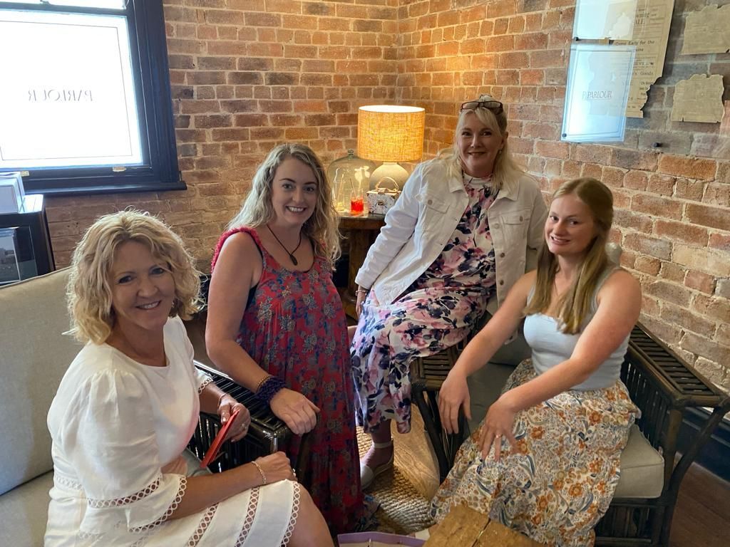Four women are posing for a picture in front of a brick wall — Vet in Shellharbour, NSW