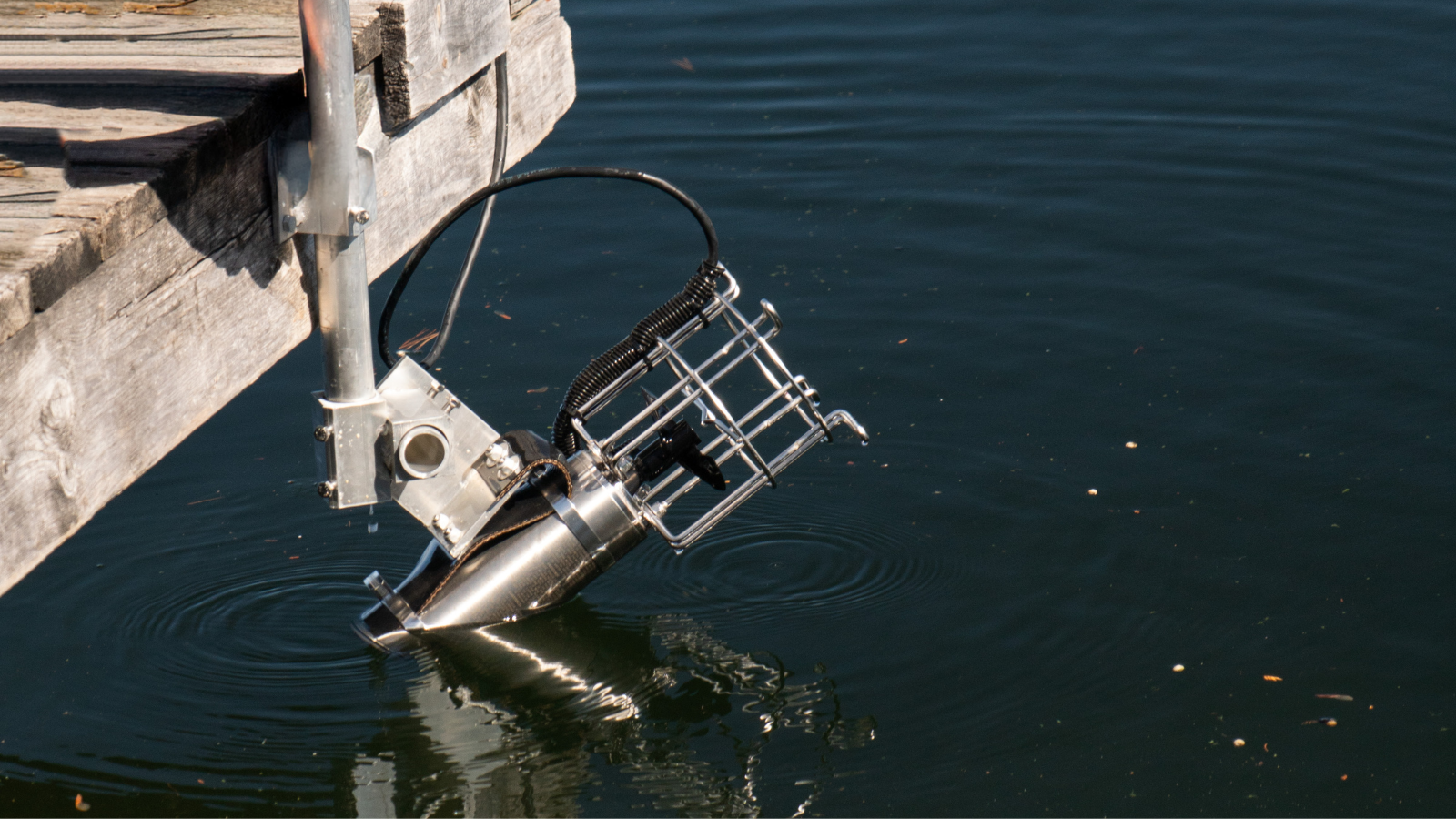 A metal object is floating in the water near a dock.