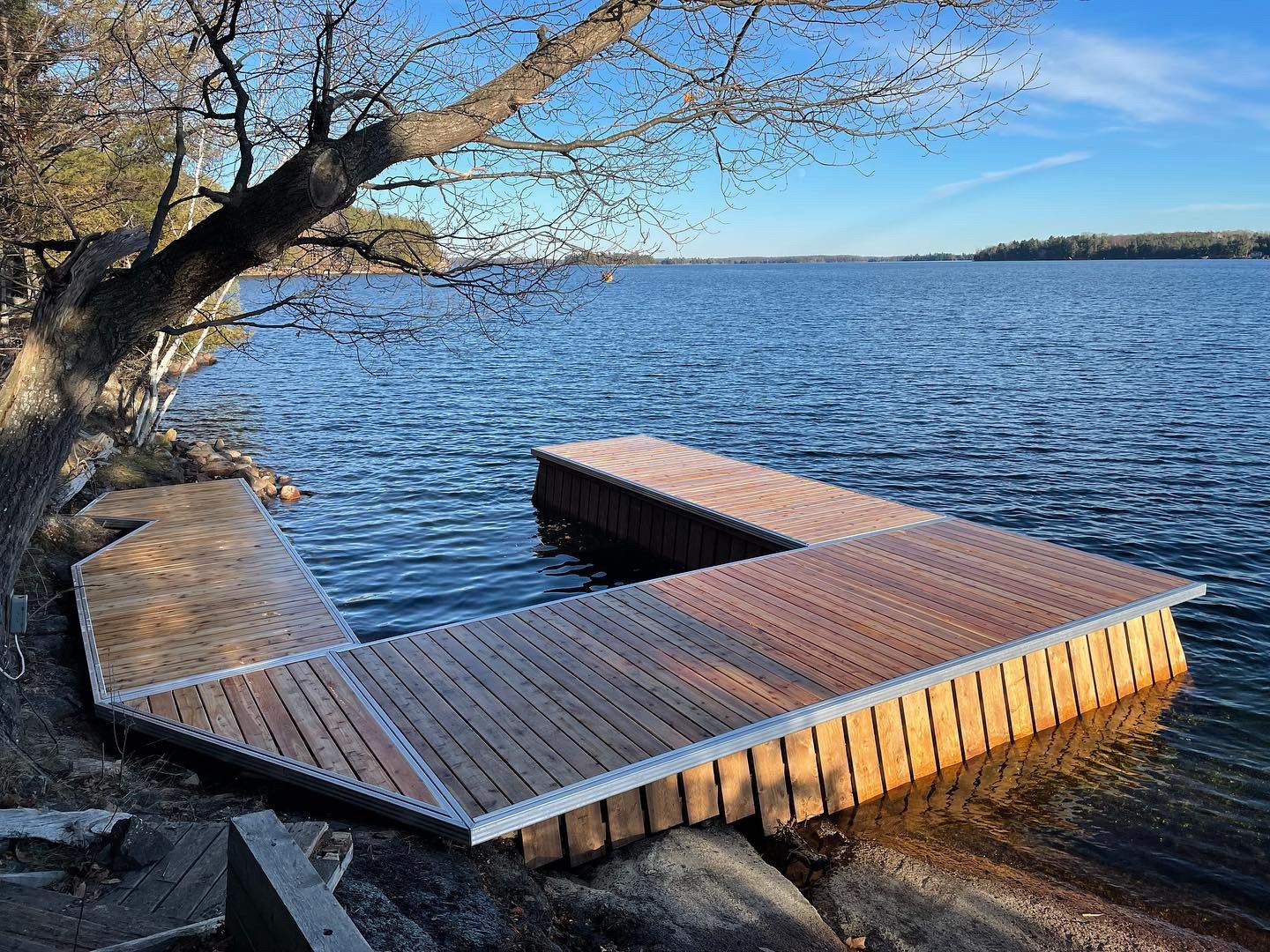 A wooden dock is sitting on the shore of a lake.