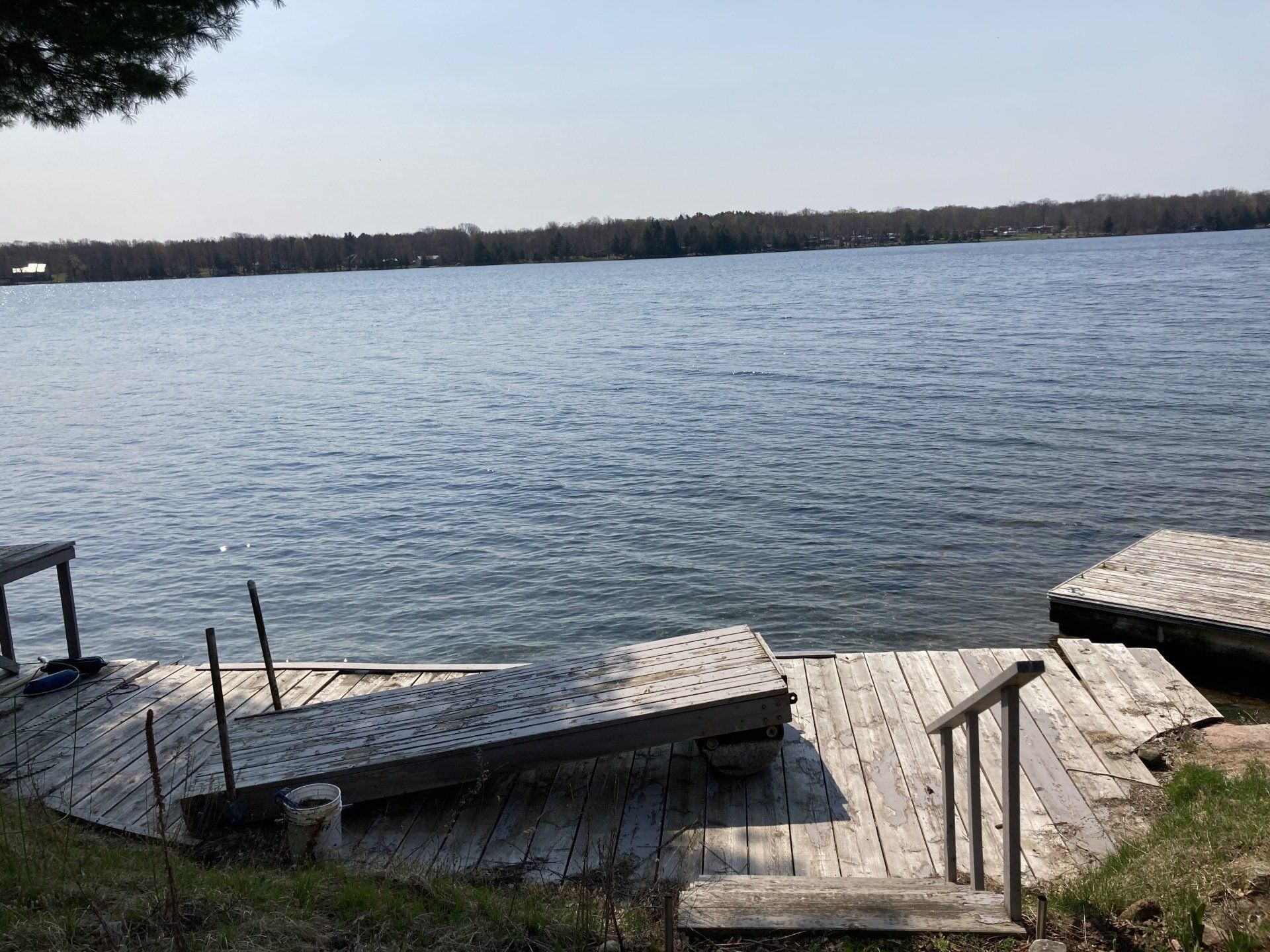 A wooden dock with stairs leading to a large body of water.
