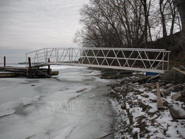 A bridge over a body of water with snow on the ground