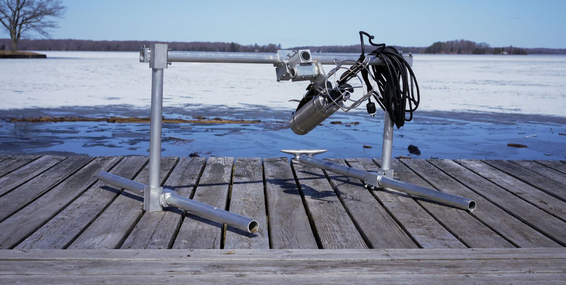 An Arbrux piece of equipment s sitting on a metal stand on a wooden dock.