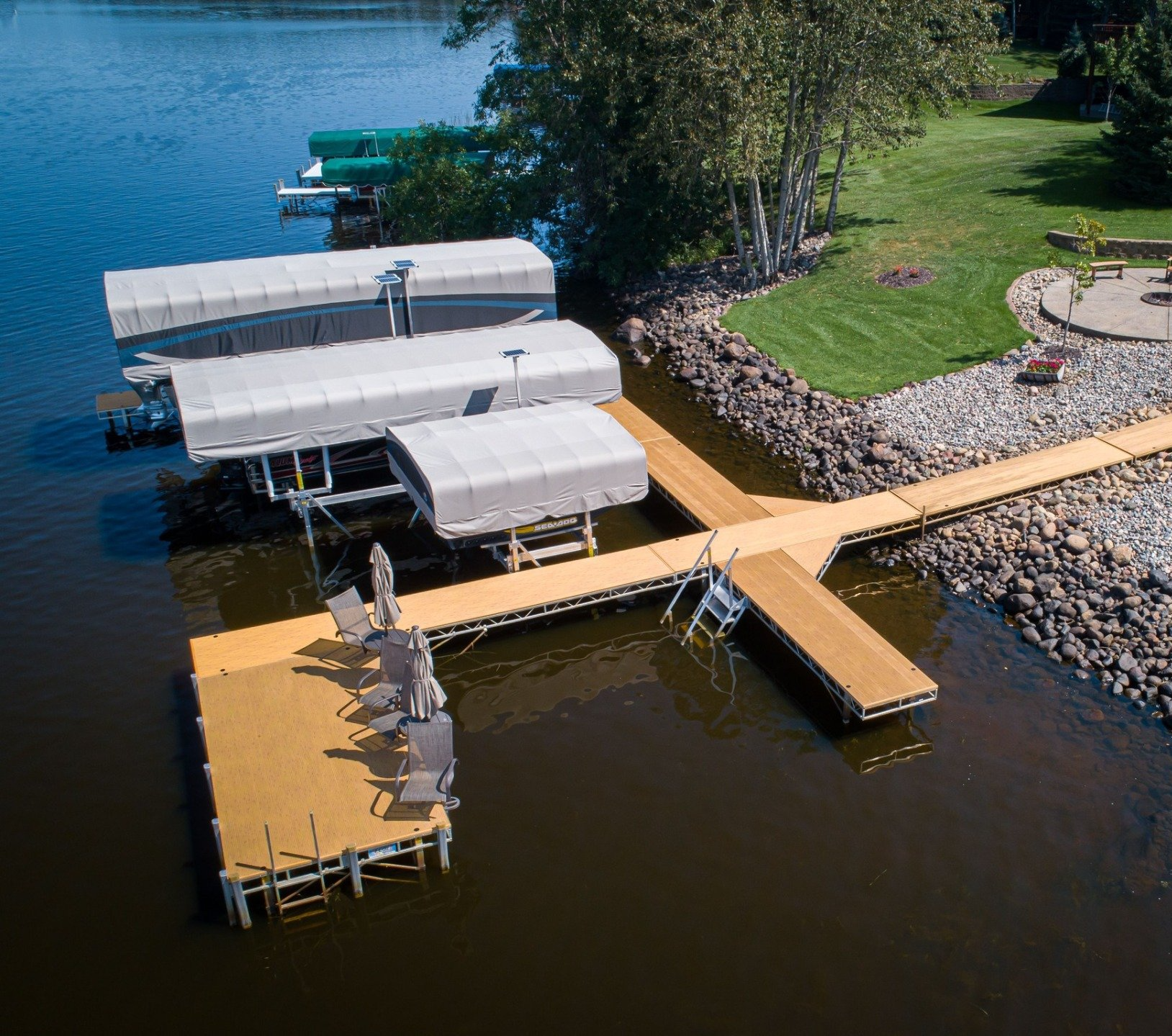 An aerial view of a dock on a lake with boats docked.