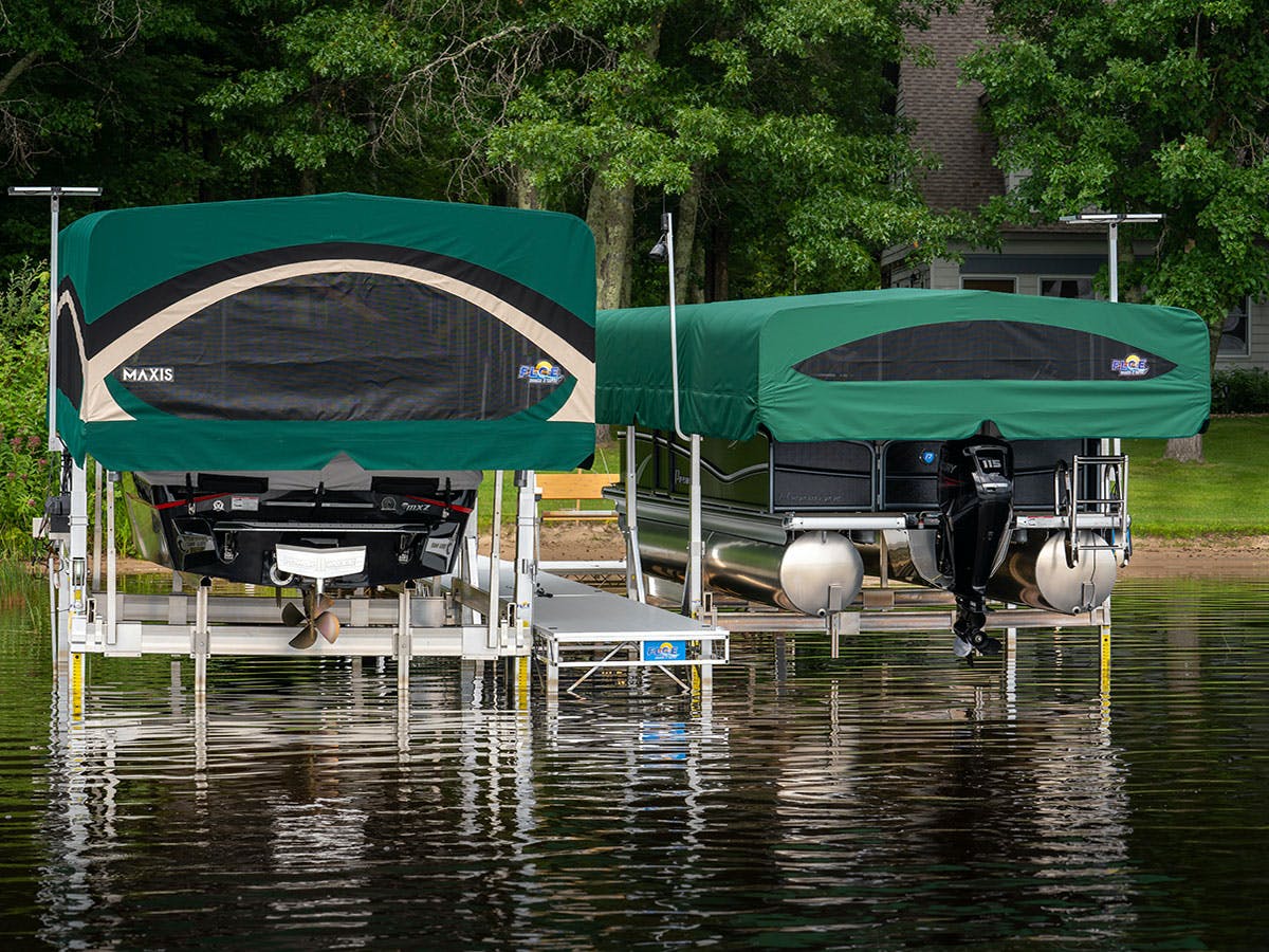 Two boats are docked at a dock on a lake.