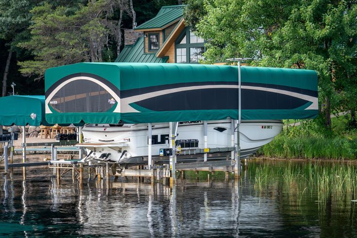 A boat is docked at a dock with a green canopy over it.