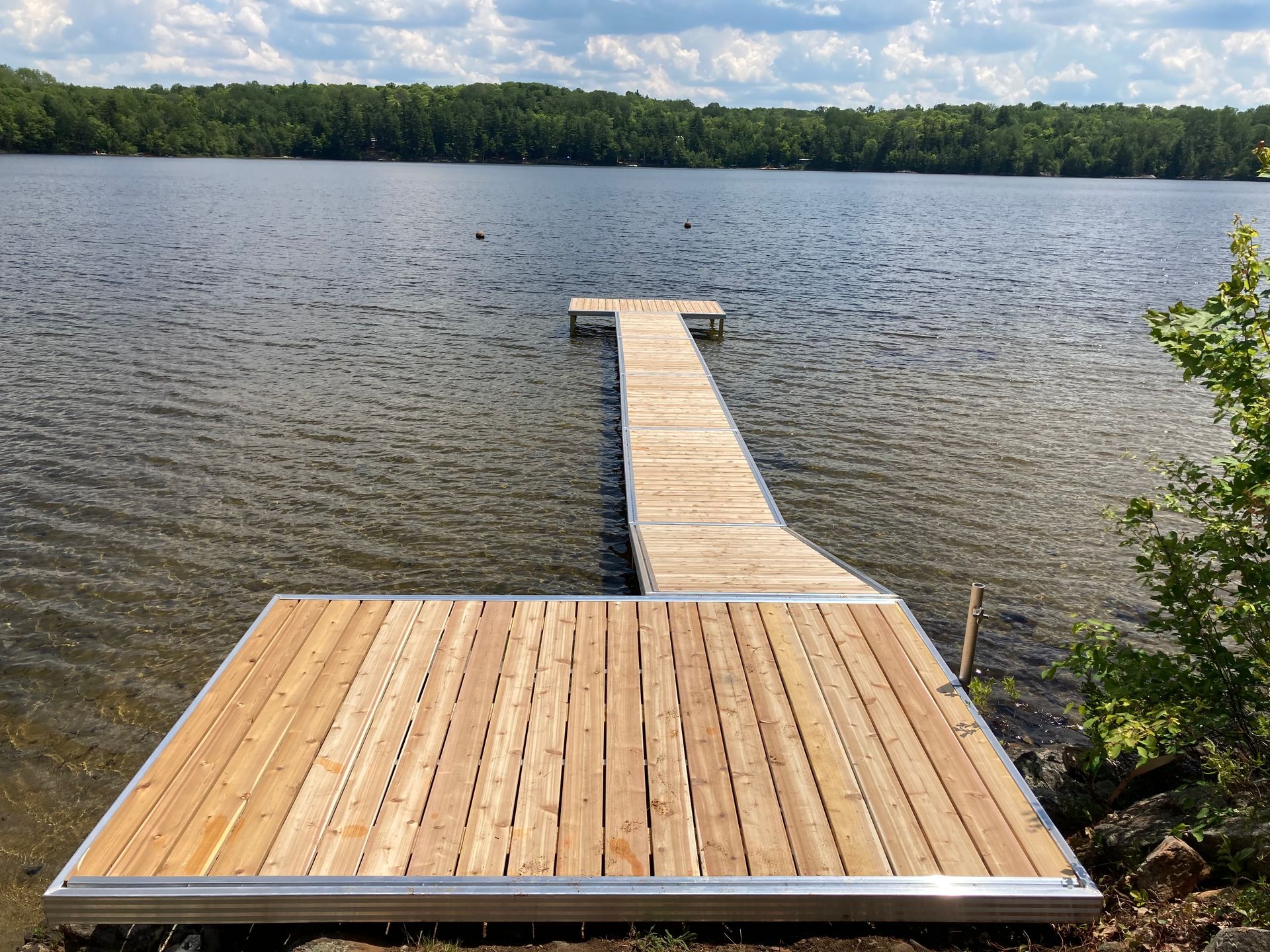 A wooden dock is sitting on the shore of a lake.