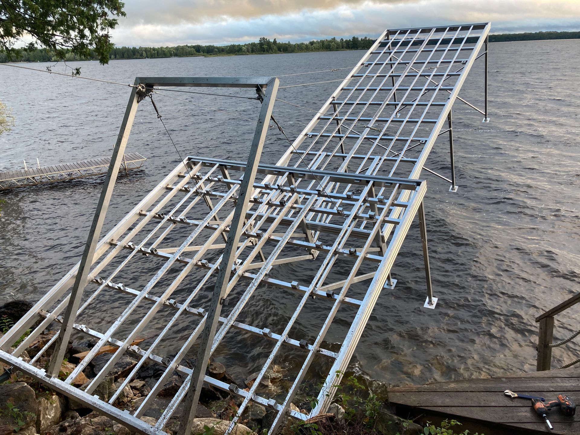 A metal structure is sitting on the shore of a lake.