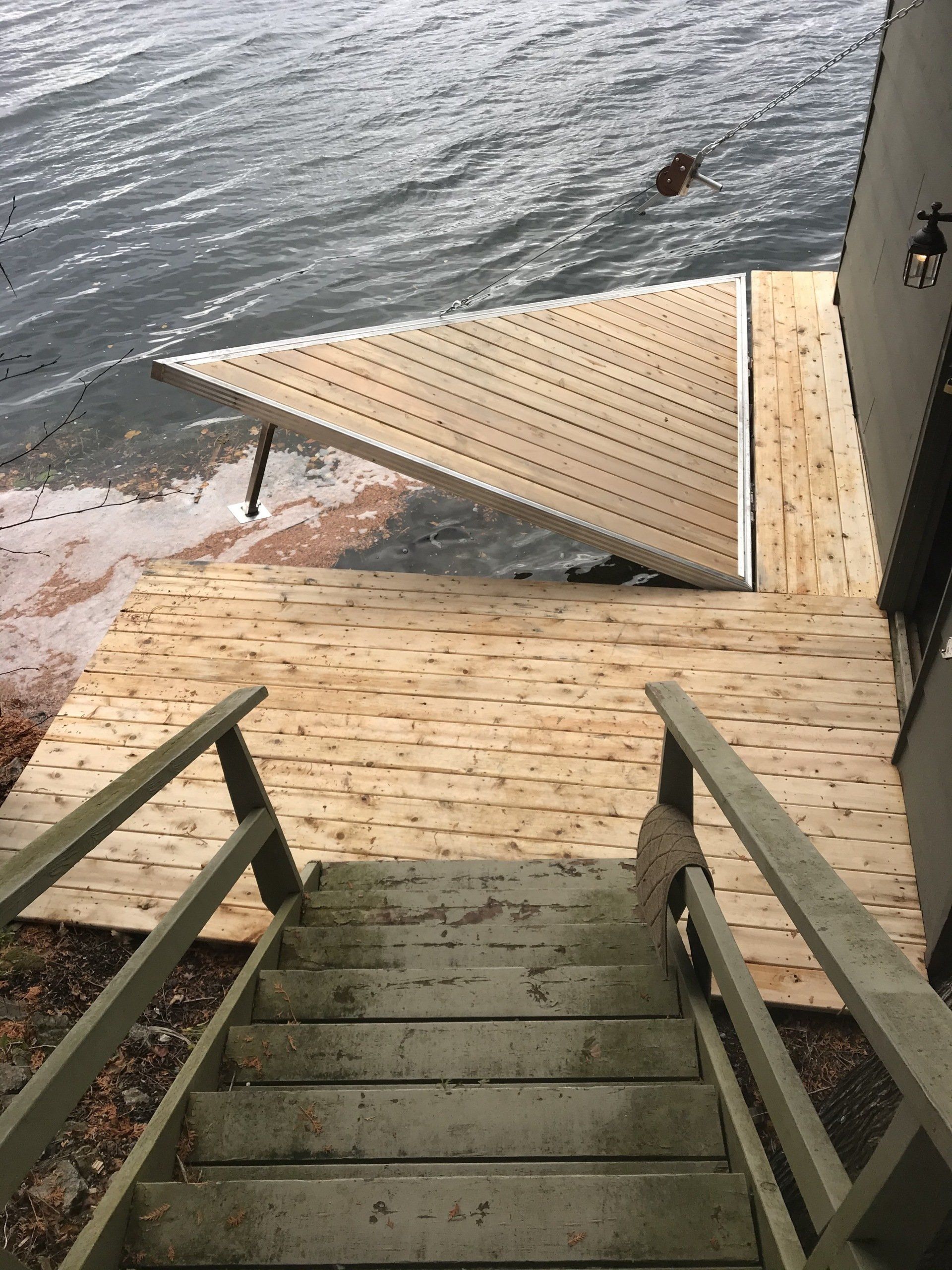 Stairs leading up to a wooden deck overlooking a body of water.