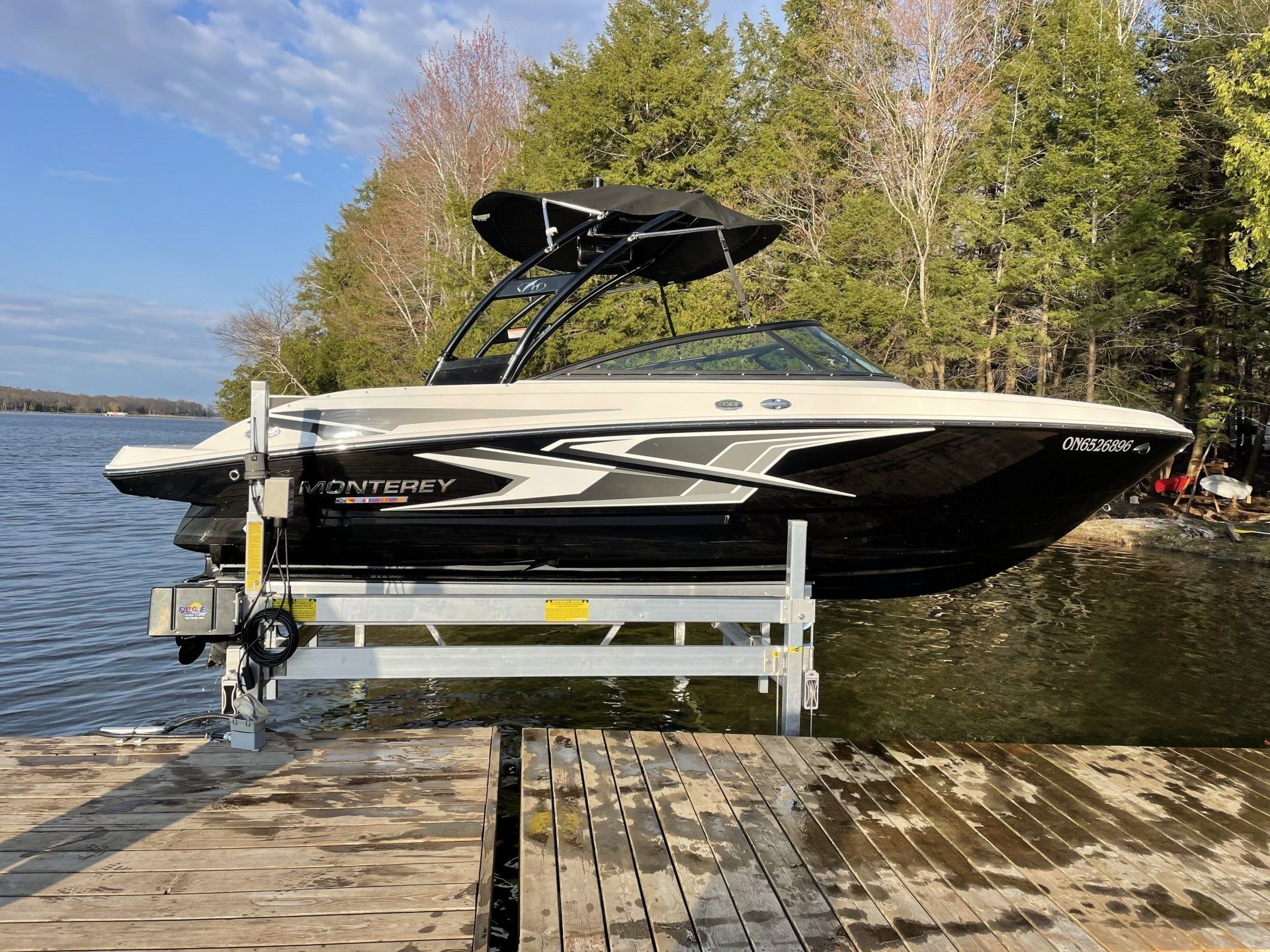 A boat is sitting on top of a dock next to a lake.