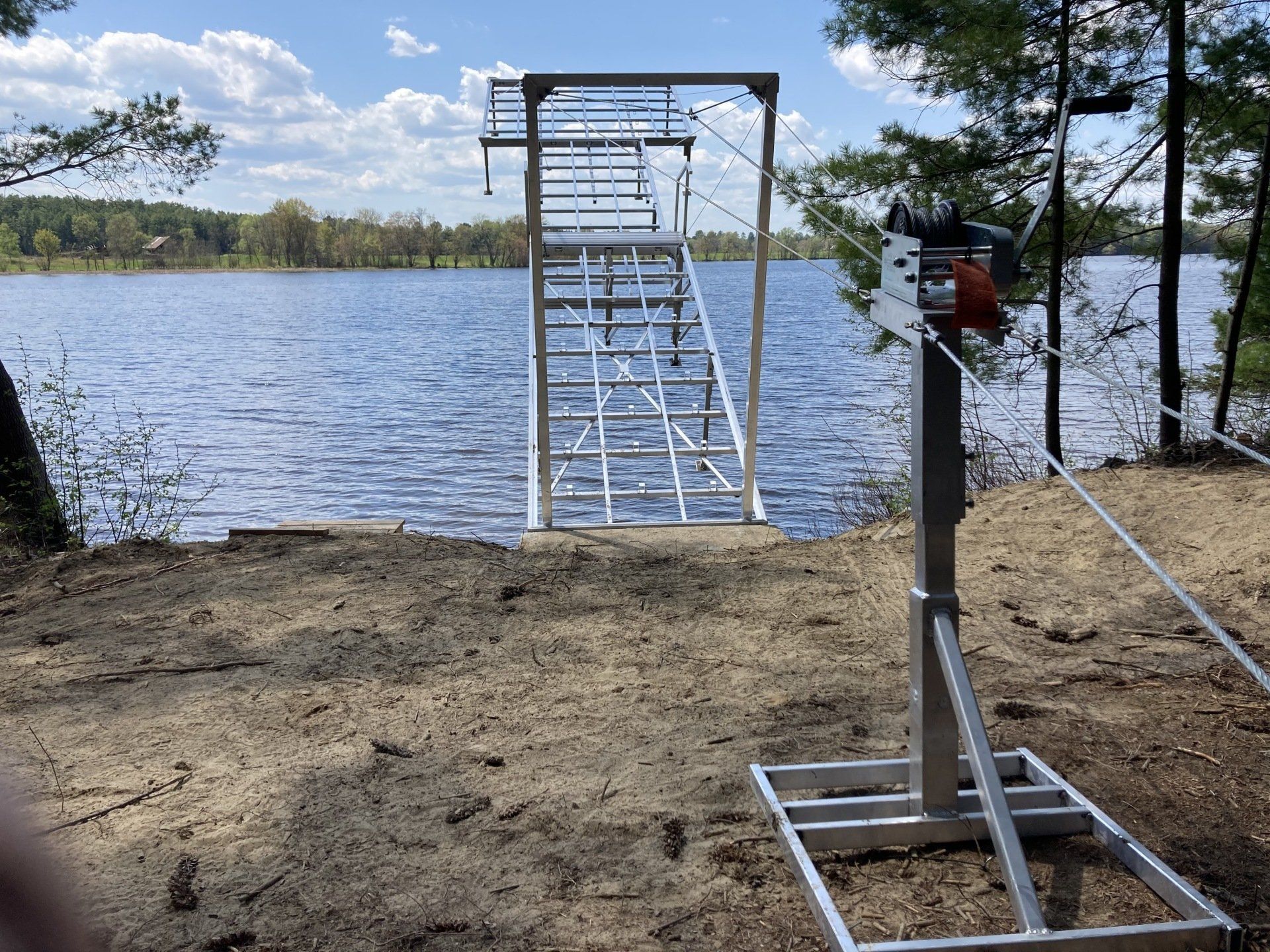 A ladder leading to a lake with trees in the background.