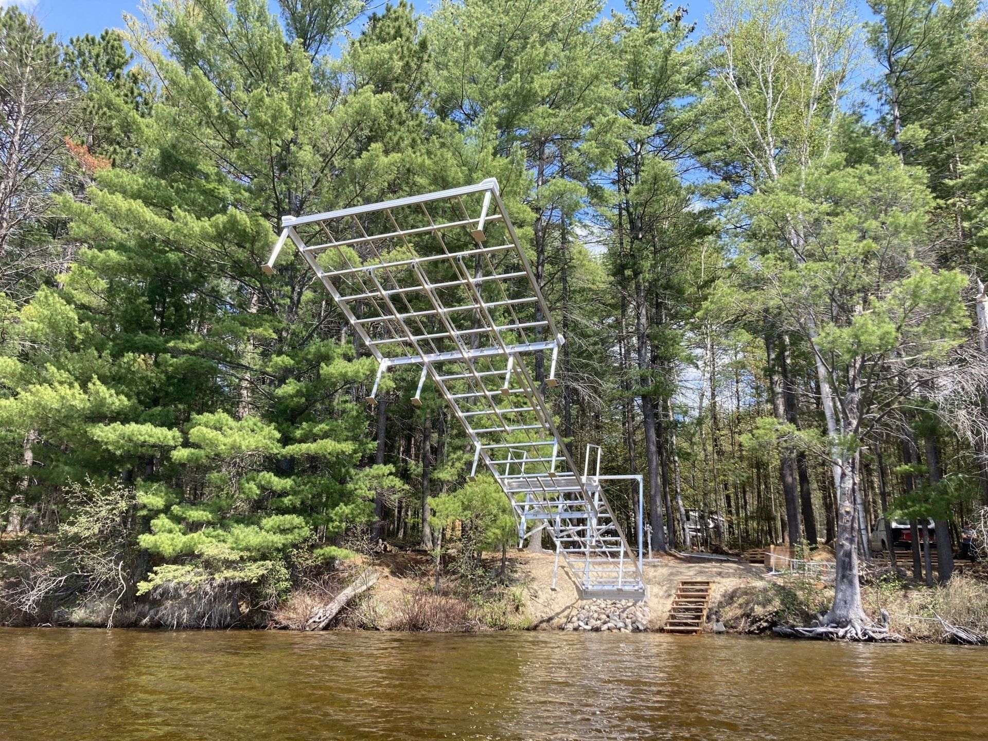 A ladder is hanging over a body of water surrounded by trees.