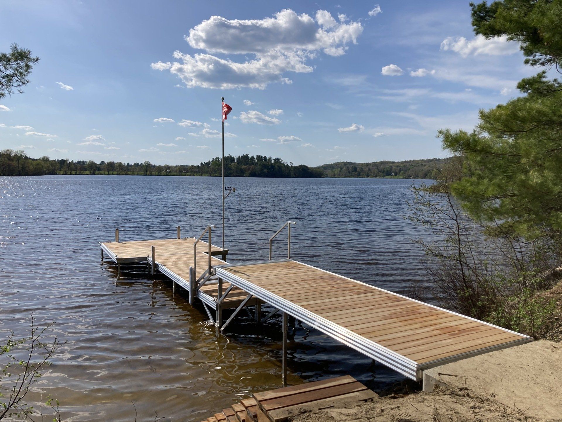 A wooden dock is sitting on the shore of a lake.