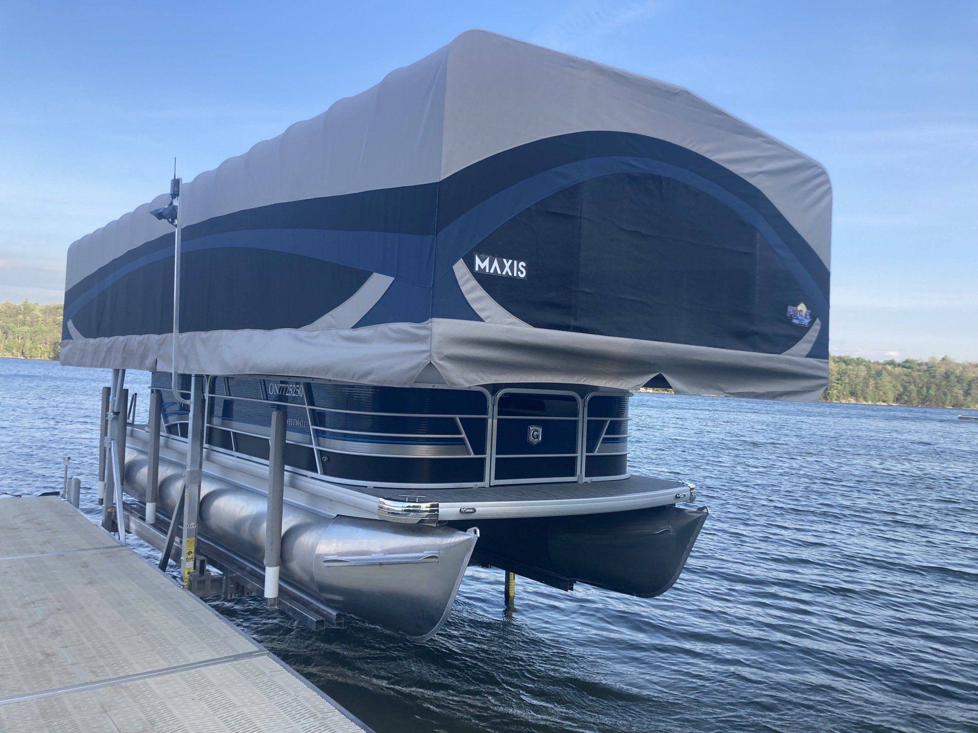 A pontoon boat is docked at a dock on a lake.