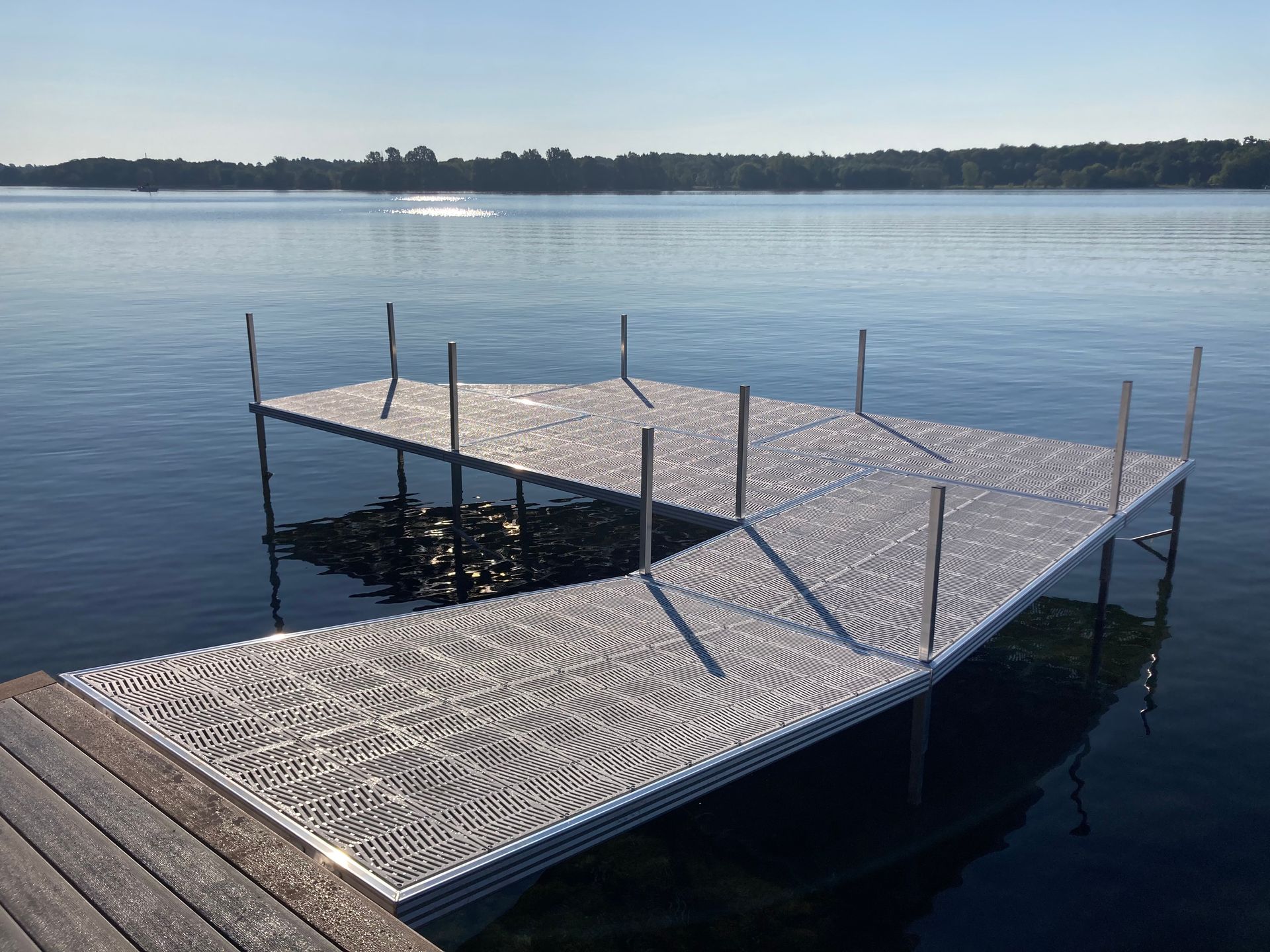 A dock on a lake with a boat in the distance.
