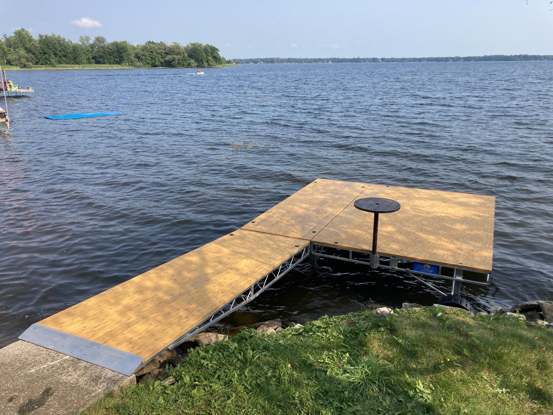 A wooden dock is sitting on the shore of a lake.