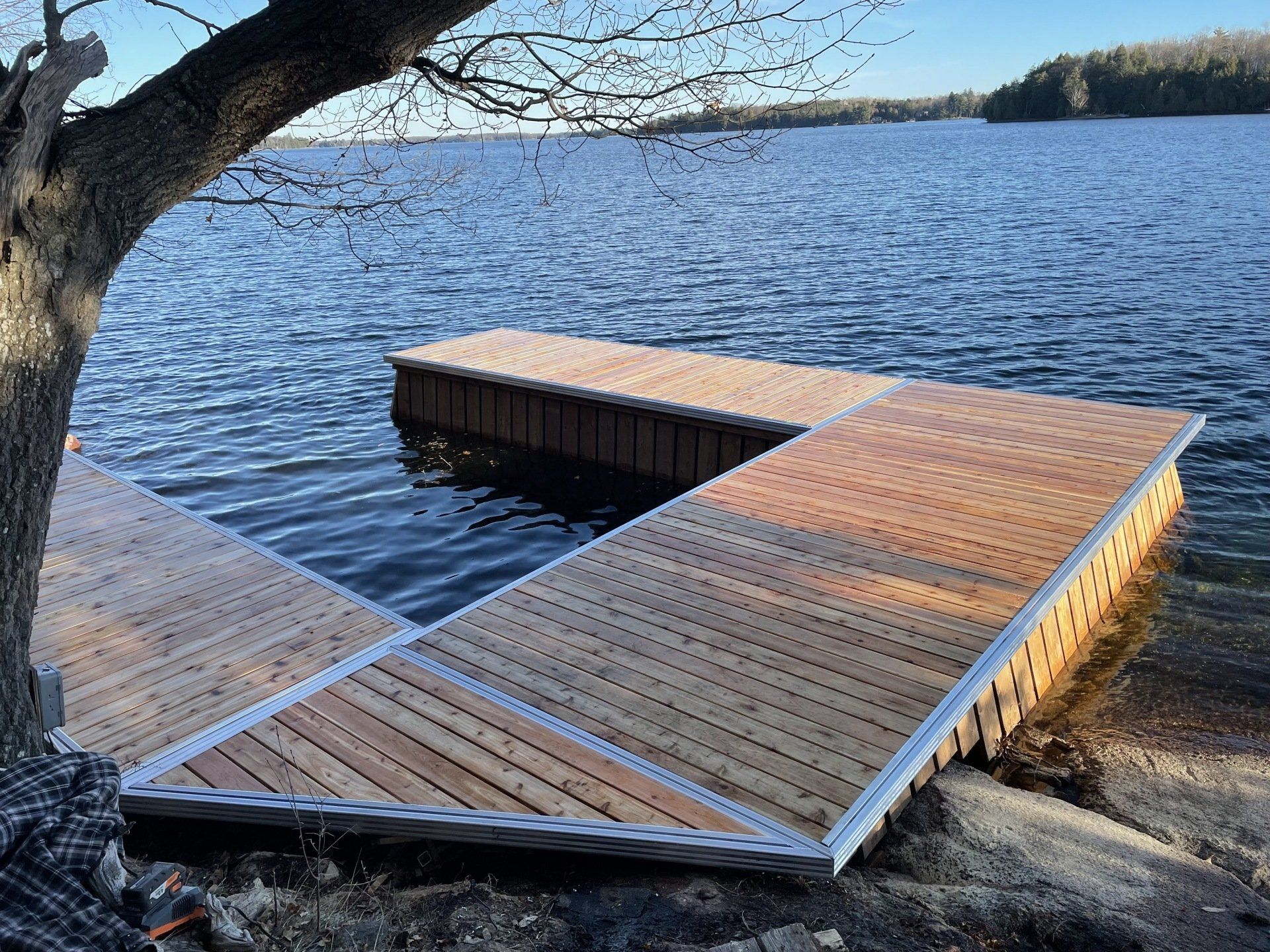 A wooden dock is sitting on the shore of a lake.