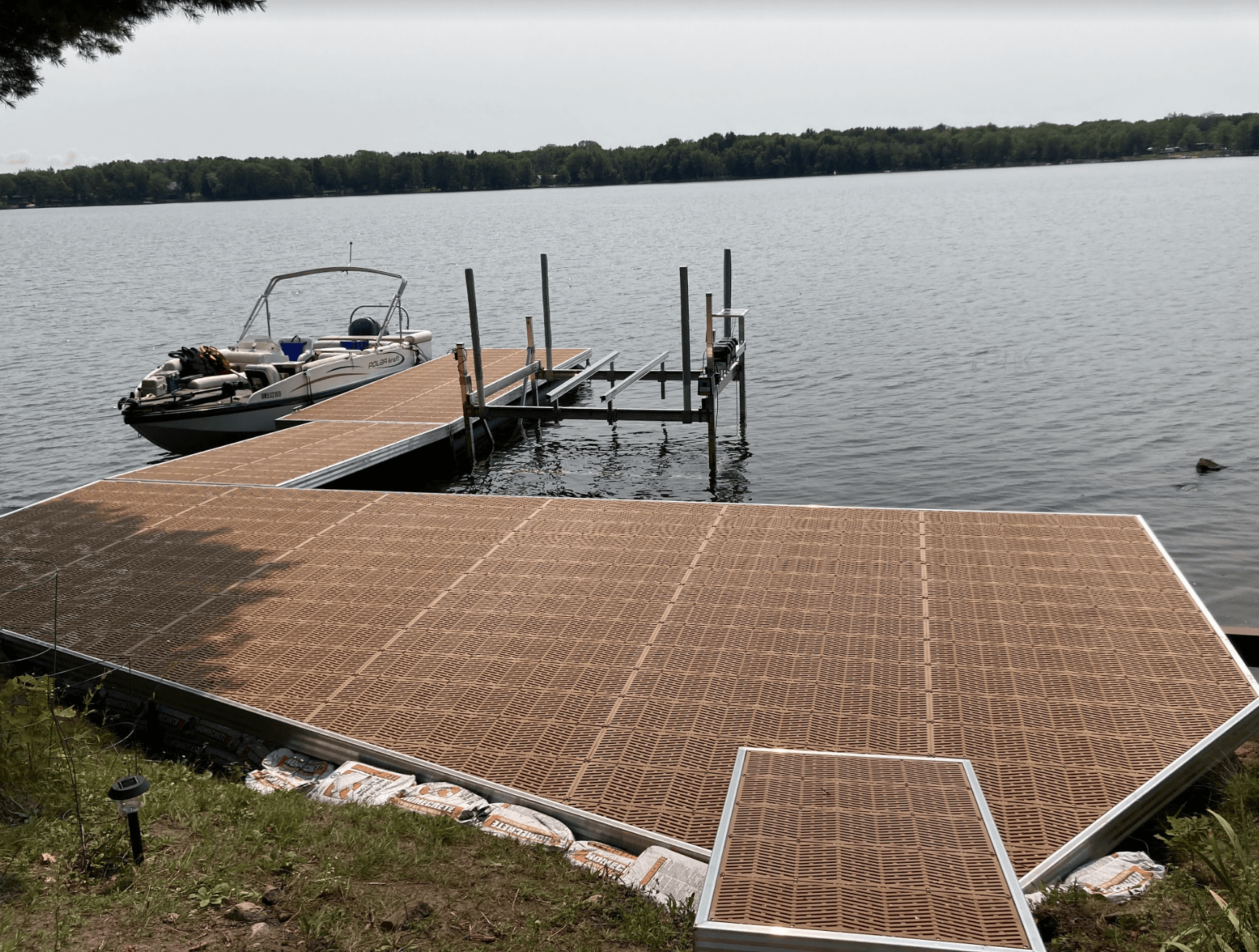 A boat is docked at a dock on a lake.