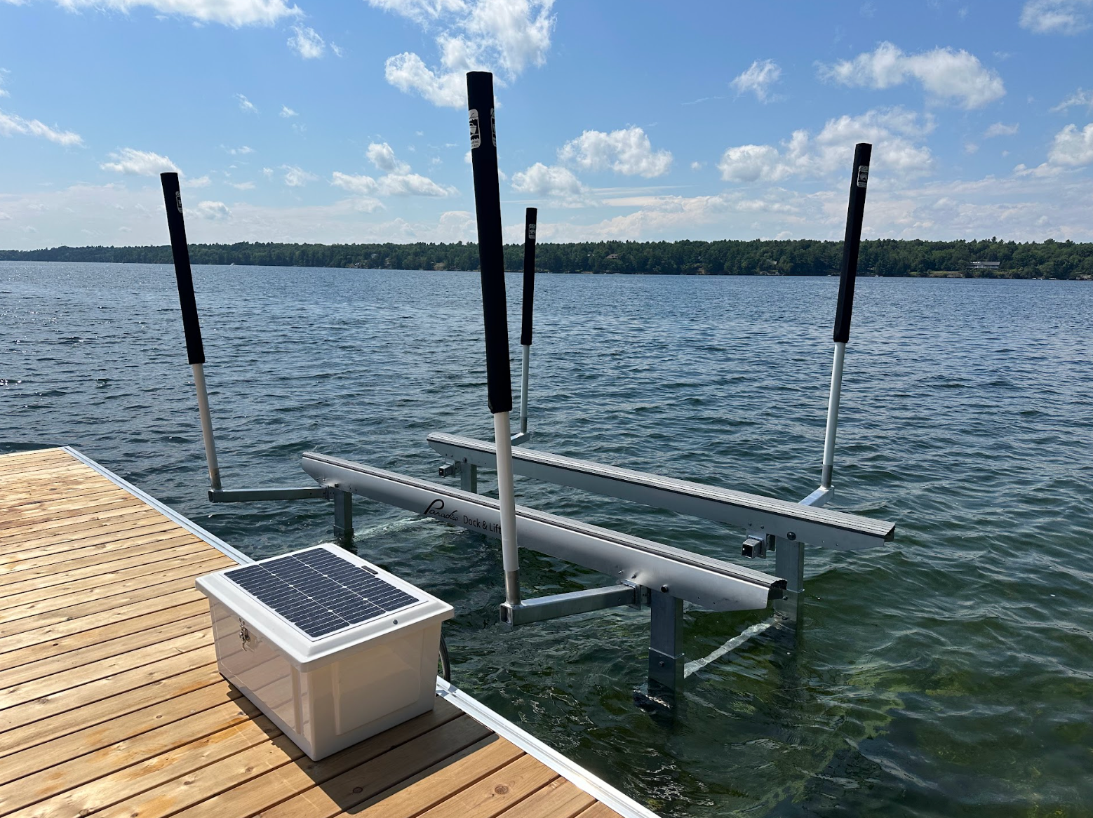 A dock with a solar panel on top of it and a boat lift in the water.