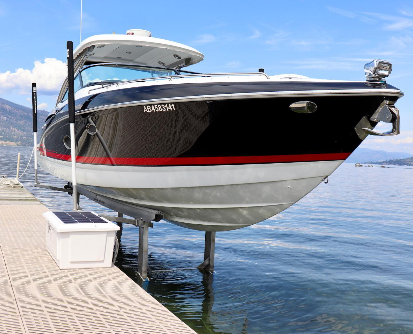 A boat is sitting on a lift in the water.