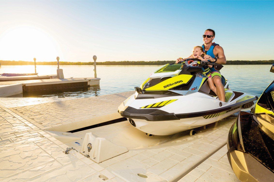 A man is riding a jet ski on a dock.