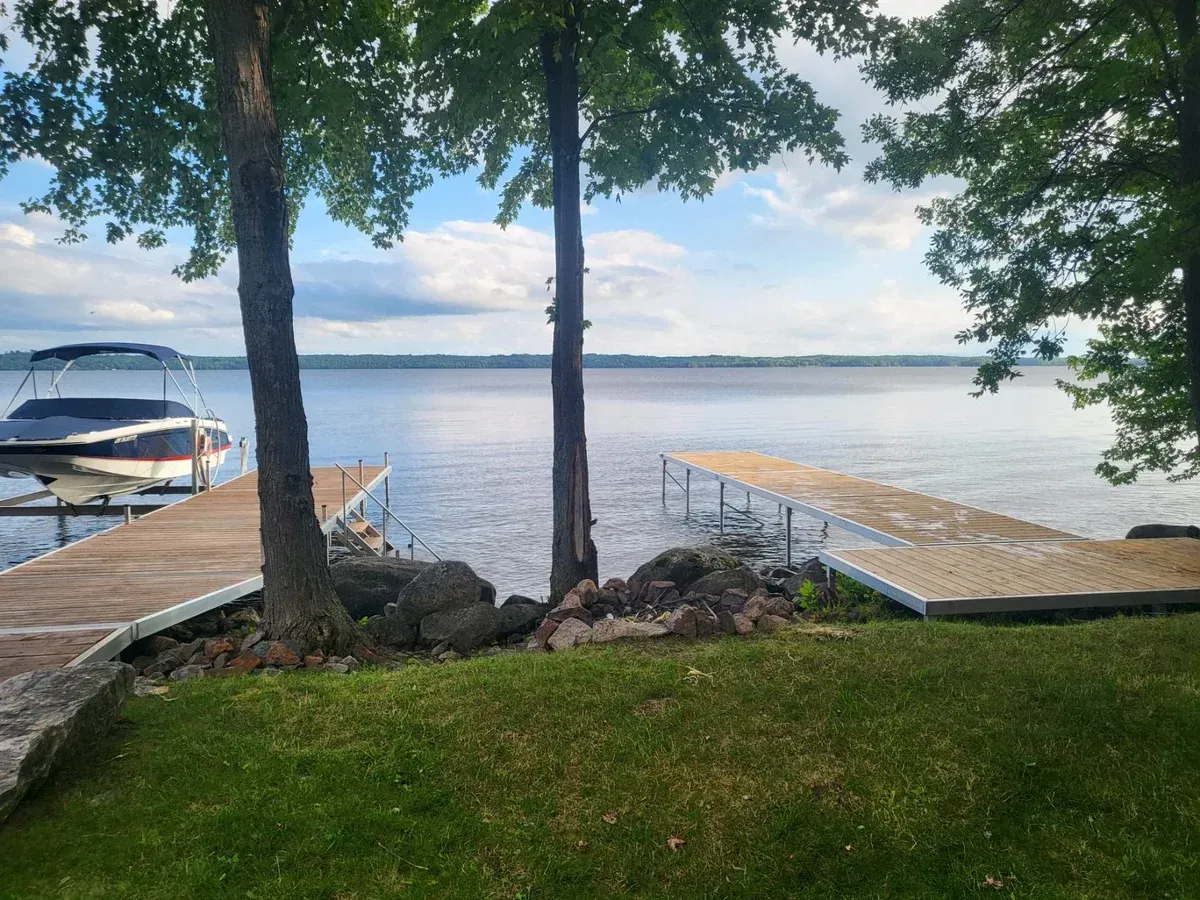 A boat is docked at a pole dock next to a lake.