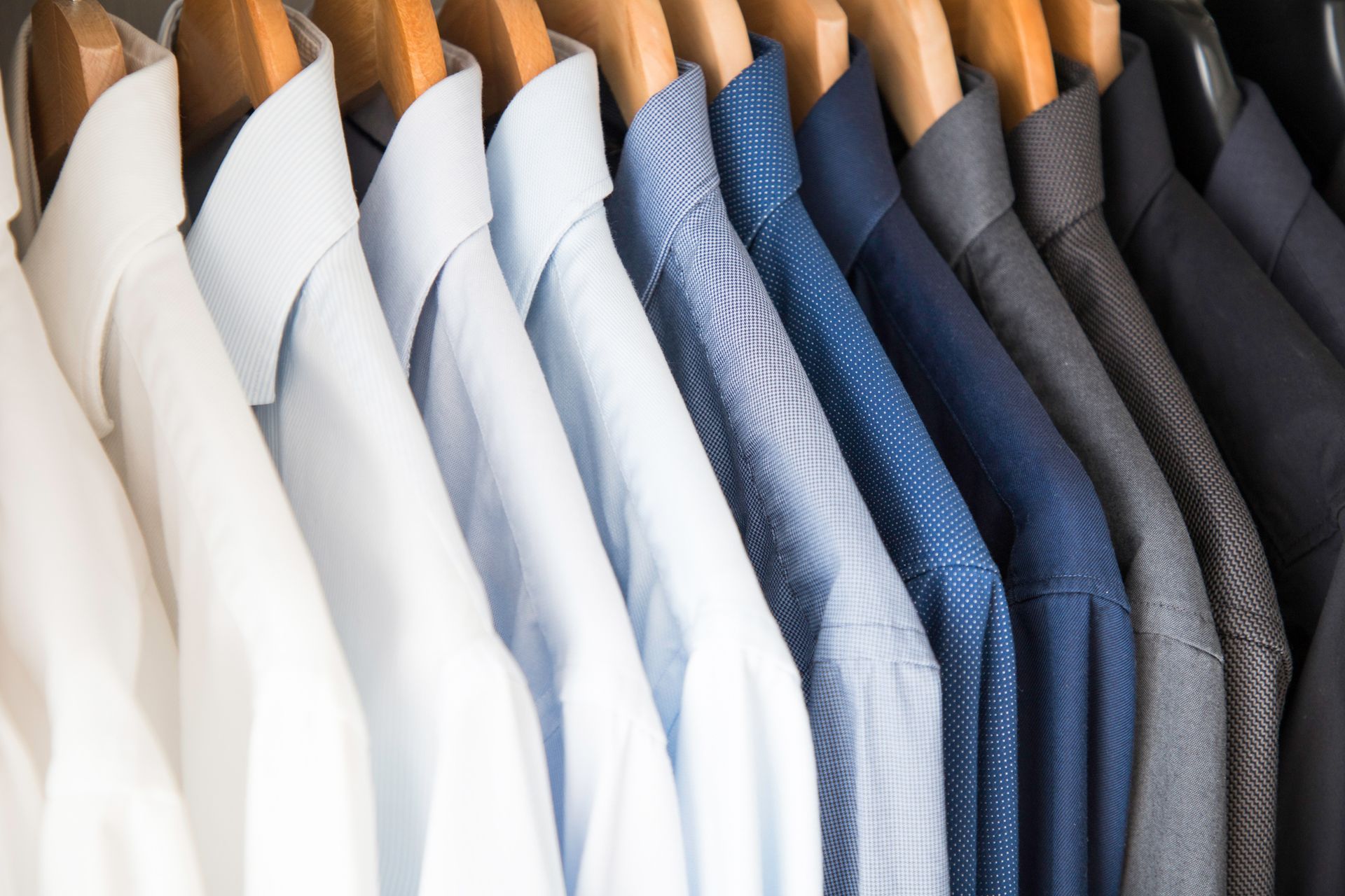 Colour-sorted shirts in the closet, showcasing expert repairs and clean finishes.