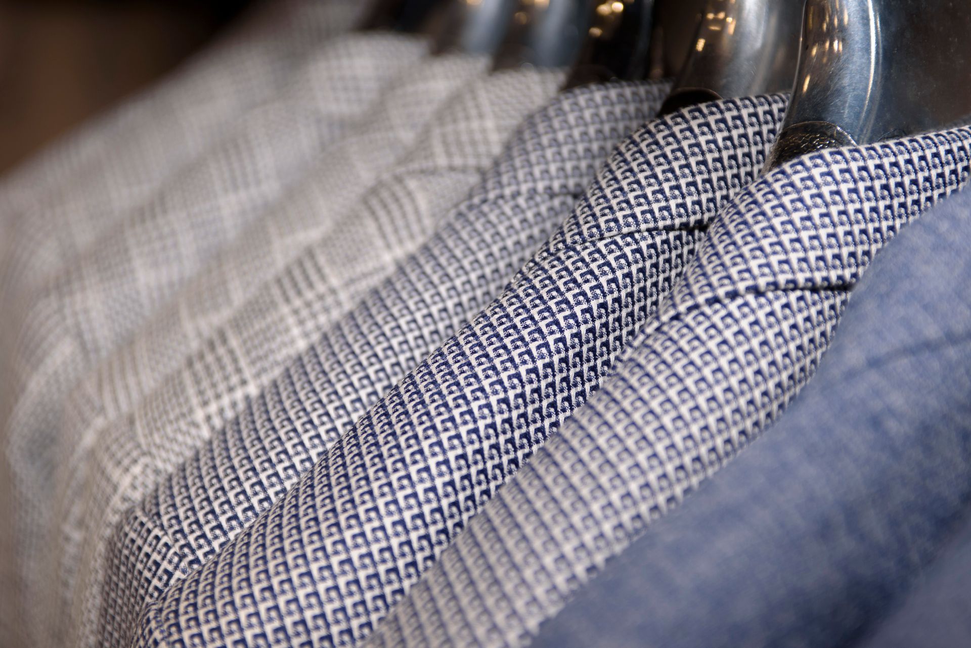 Men’s jackets organized, highlighting sharp cuts and flawless repairs.