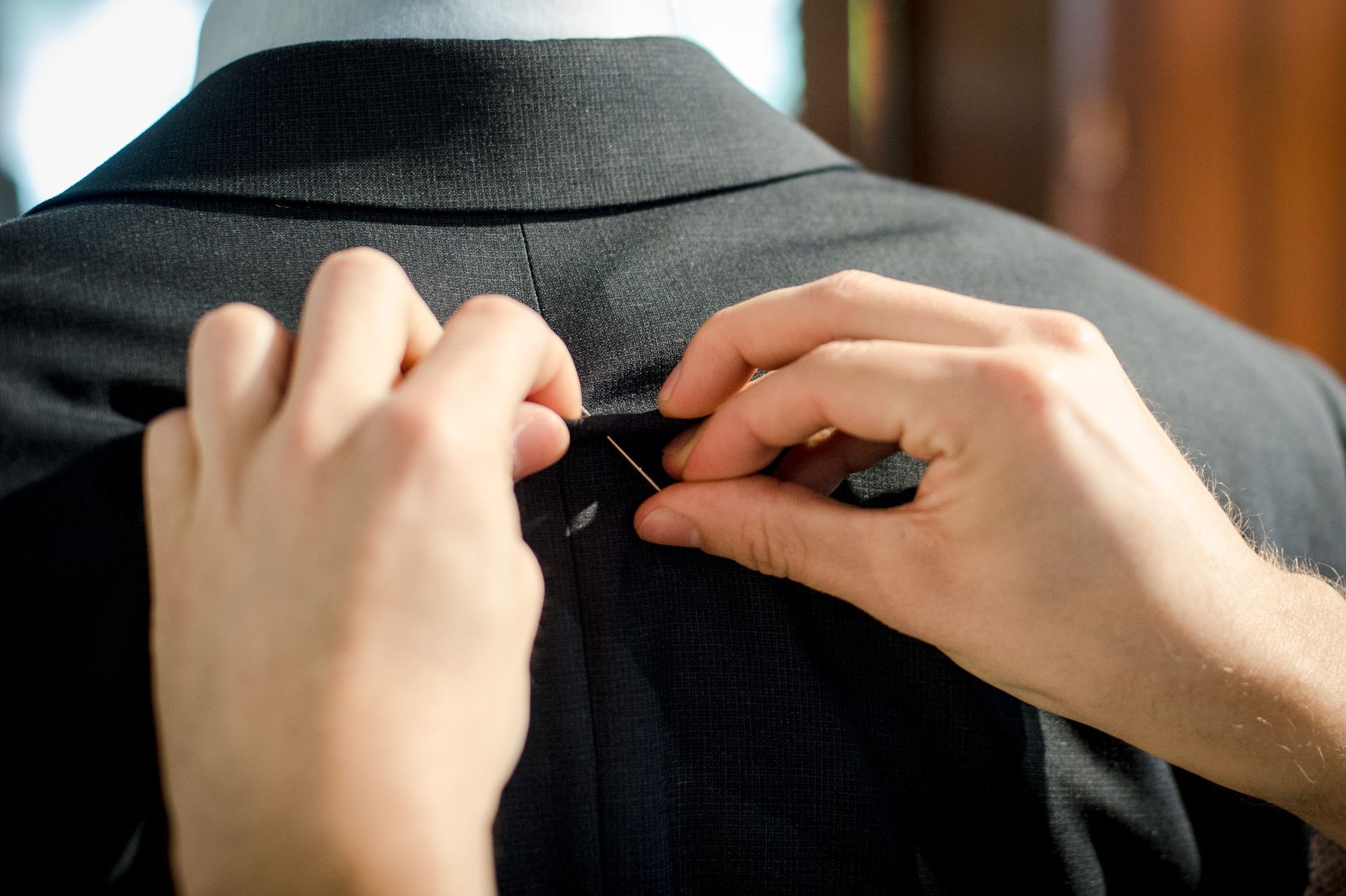 Pinning a suit for a fitting.