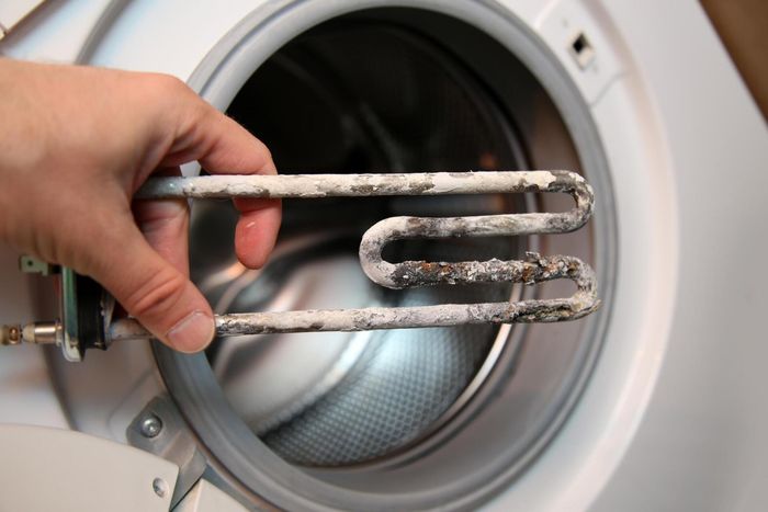 someone holding a rusty part of washer