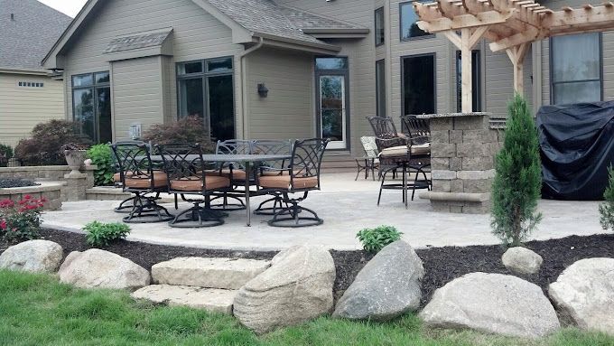 A patio with a table and chairs in front of a house.