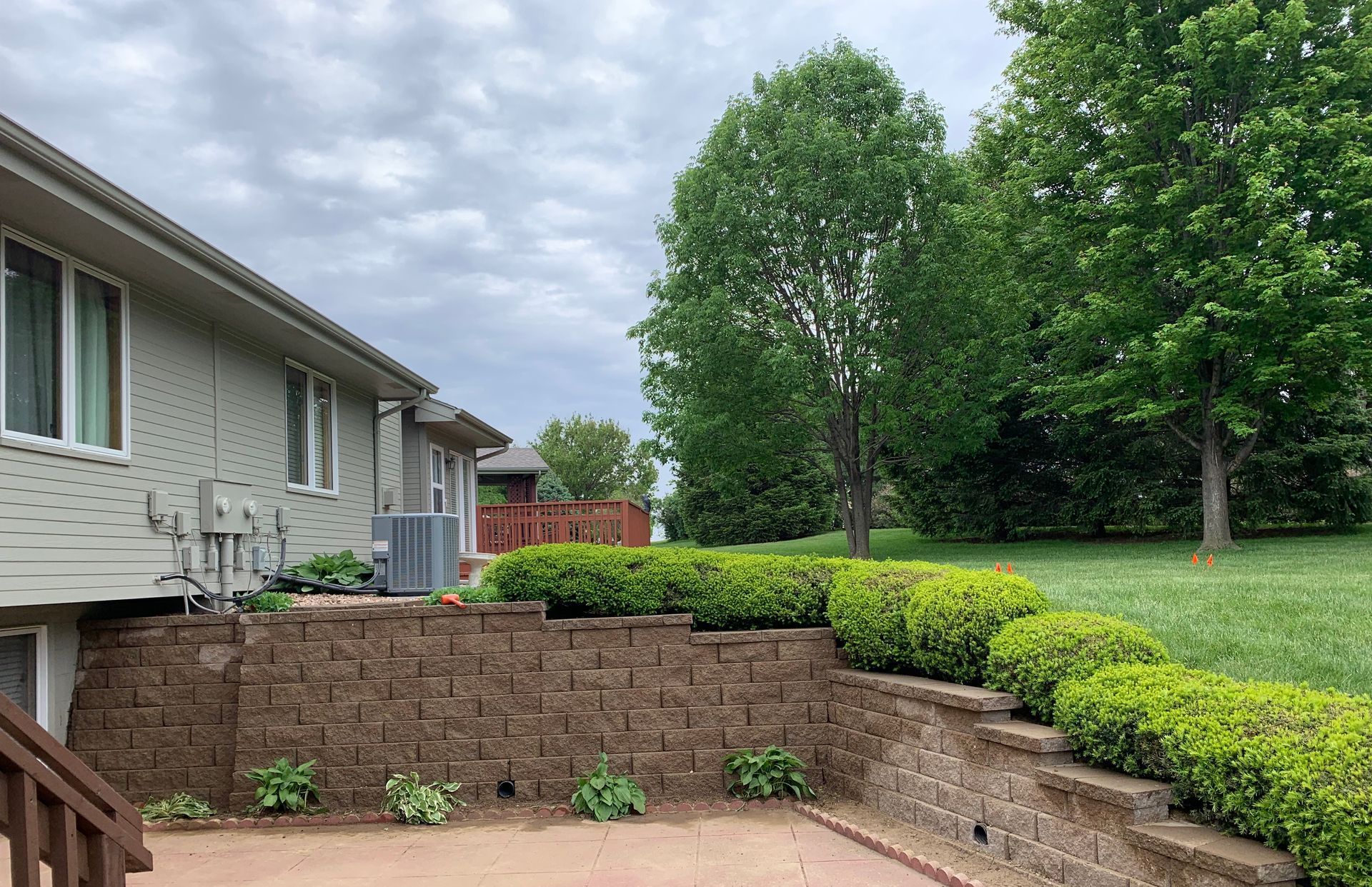 A house with a brick wall and a patio in front of it.
