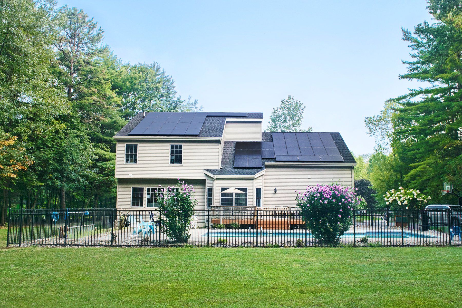 back of house with solar panels and pool