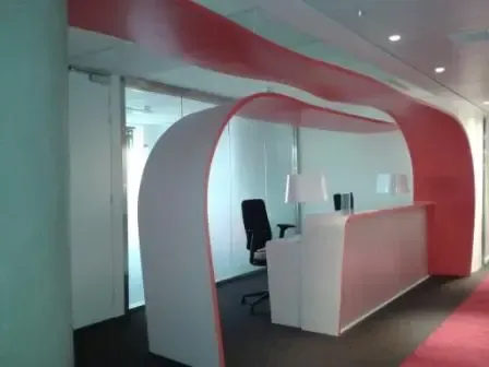 Une pièce rouge et blanche avec un bureau et une chaise. Aménagement de bureaux et locaux professionnels - SPAC