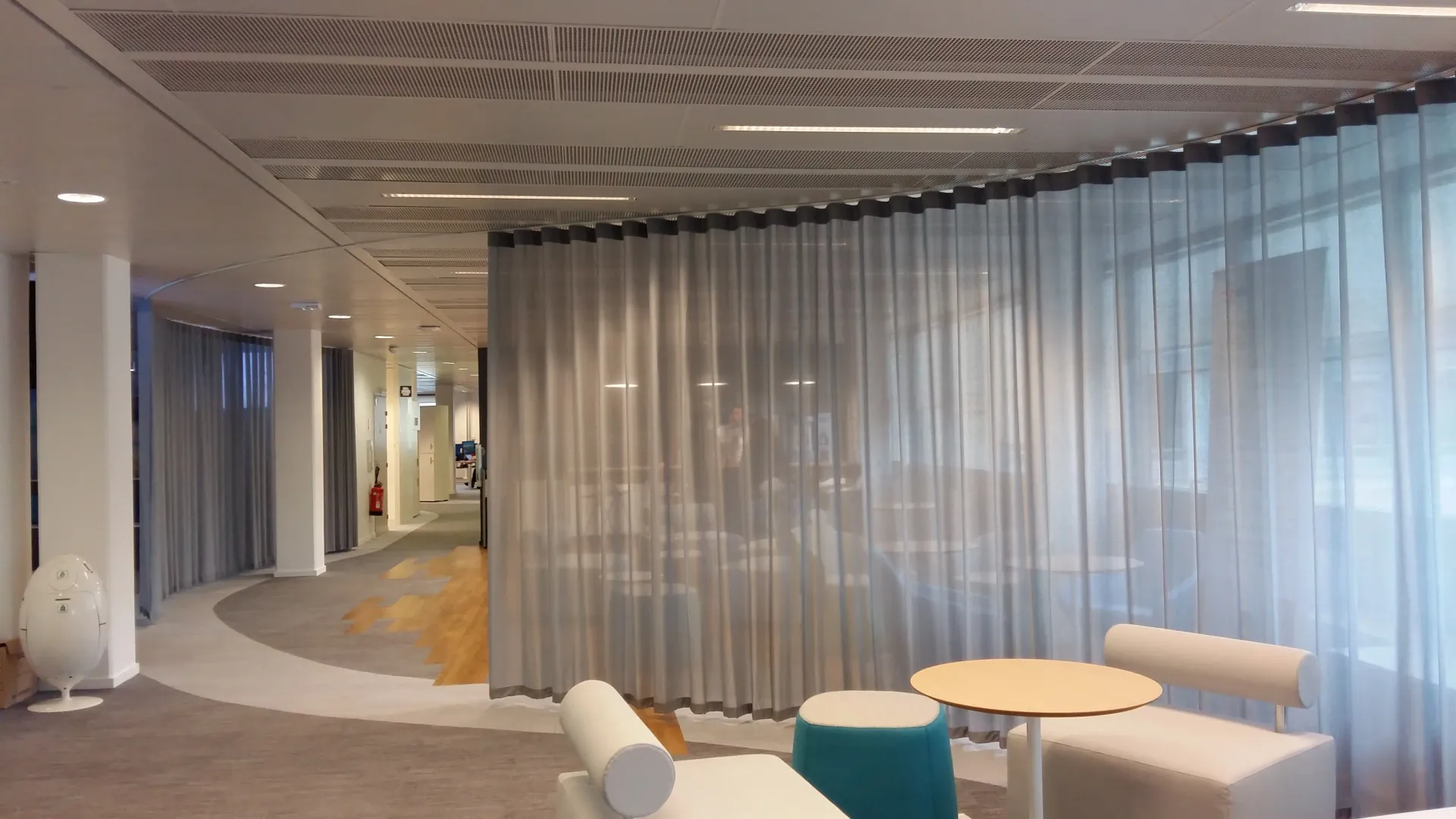 Une pièce avec un canapé, des chaises, des tables et des rideaux. Aménagement de bureaux et locaux professionnels - SPAC