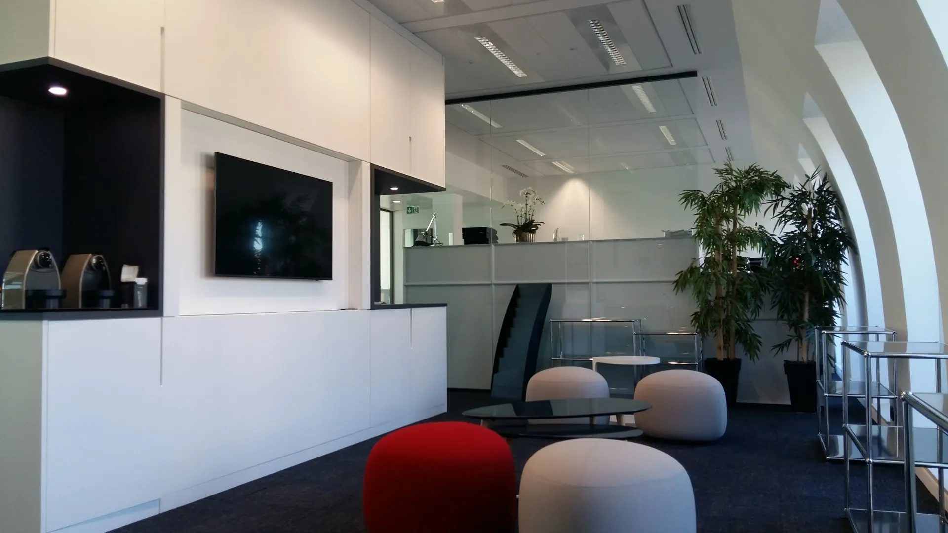 Un salon avec une télévision à écran plat au mur. Aménagement de bureaux et locaux professionnels - SPAC